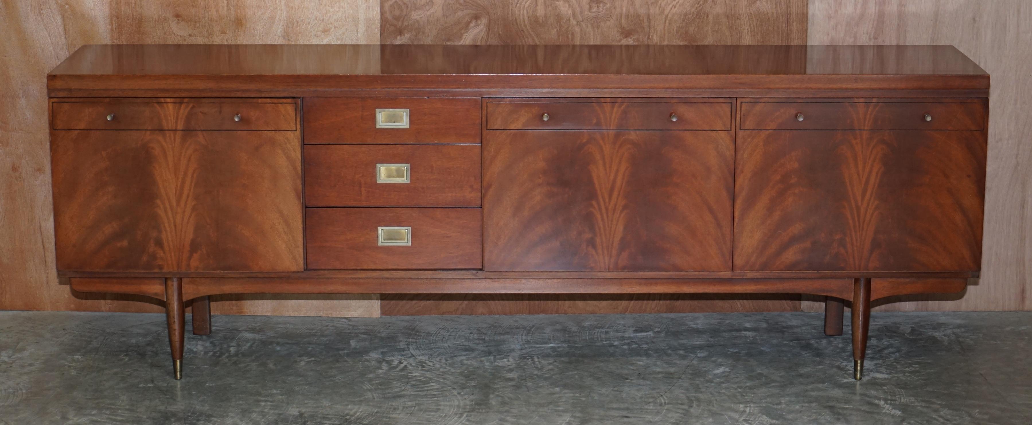 We are delighted to offer for sale this lovely Greaves 7 Thomas 1966 stamped flamed mahogany sideboard with campaign handles.

A very good looking and well made piece of mid century modern art furniture. The frame is all mahogany with flamed