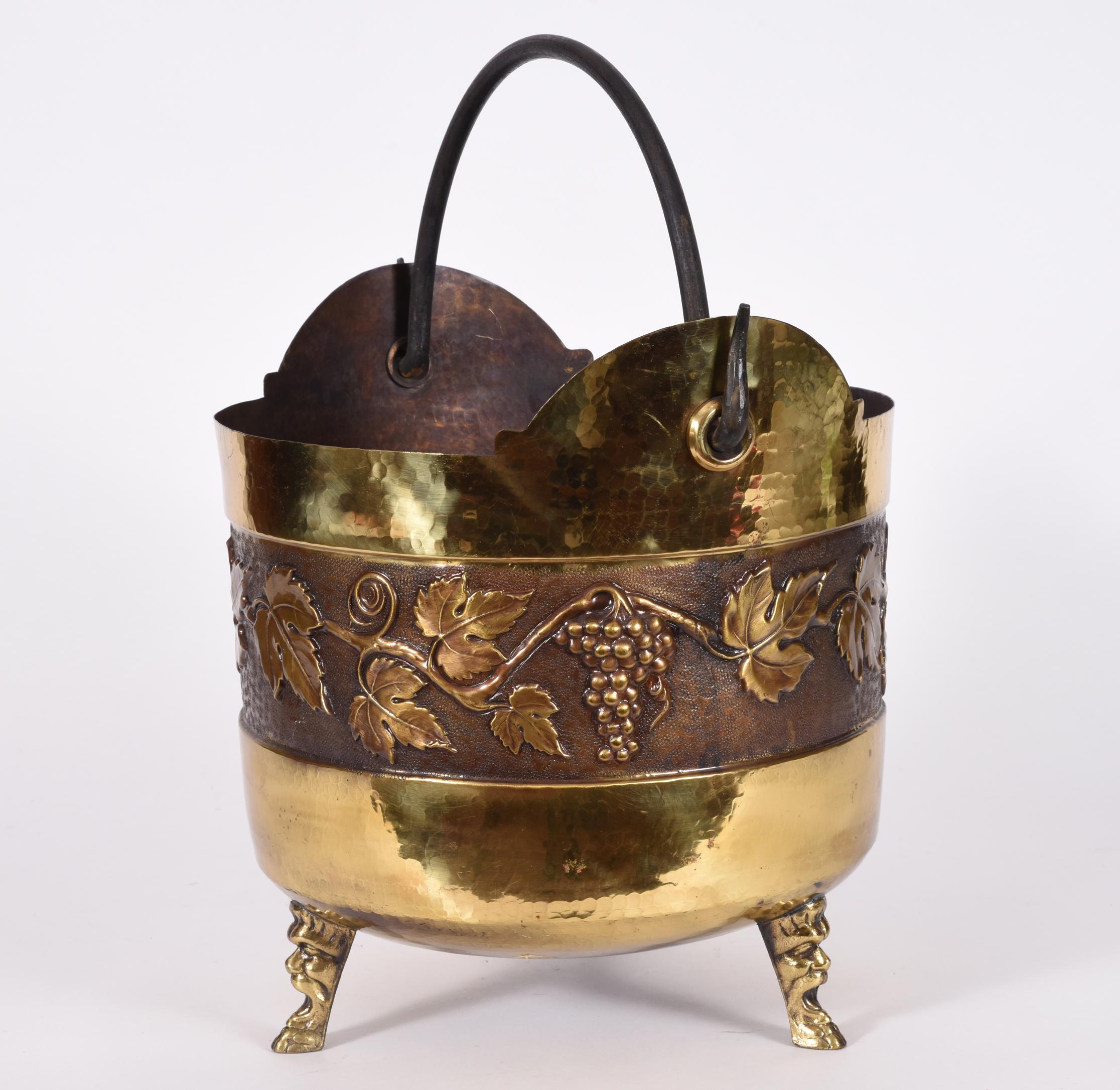 Vintage Greco Roman style copper scuttle fire place bucket in a round footed shape and very attractive pan face figural feet and grape leaf design motif. The scuttle bucket is in excellent vintage used condition, and it is ready to go to work and