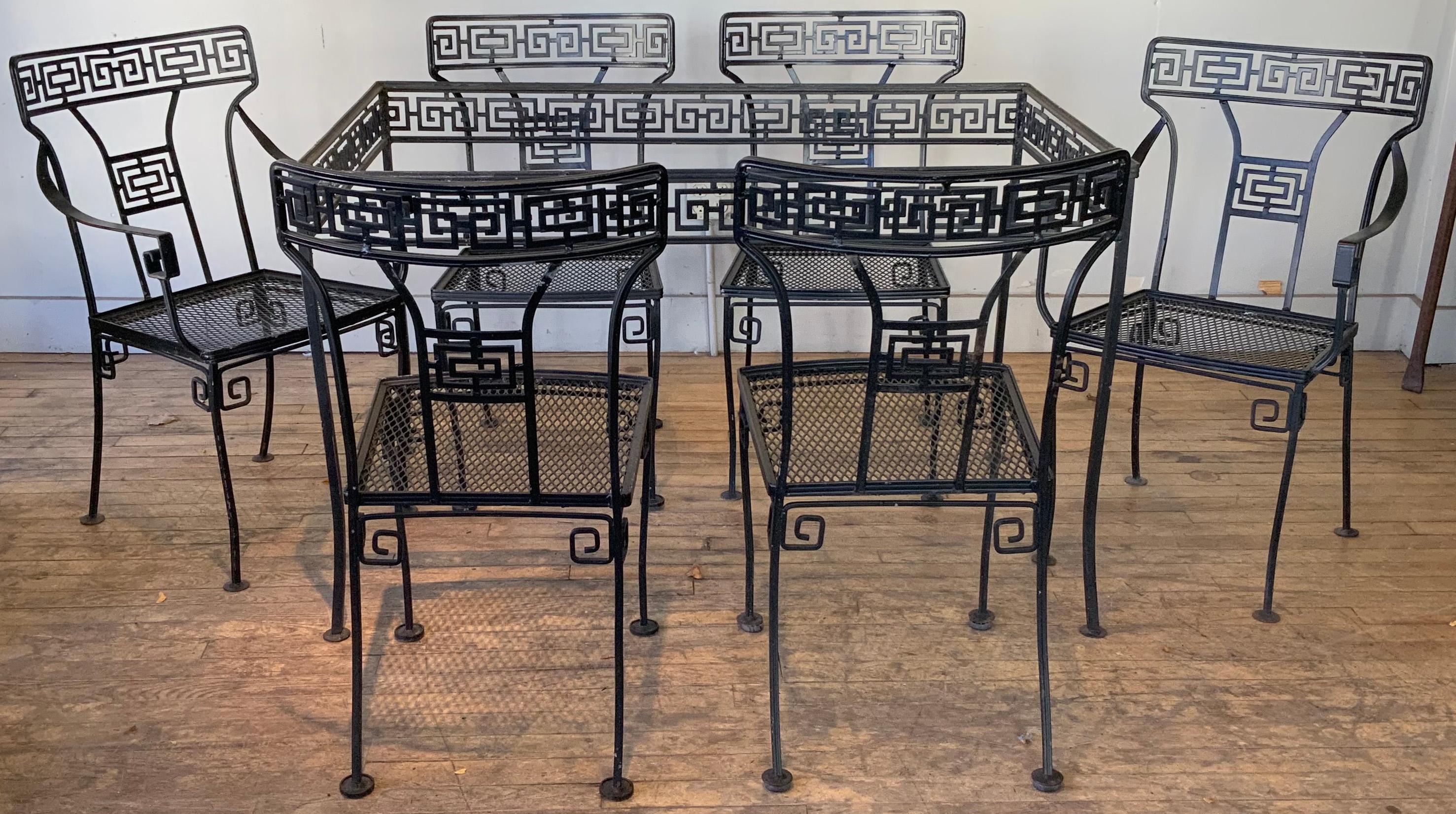 A classic and beautiful 1950s wrought iron dining table and set of six chairs by Meadowcraft. This design was called 'Athena', with all the pieces having a beautiful Greek key pattern around the skirt of the table and in the seatbacks of the chairs.