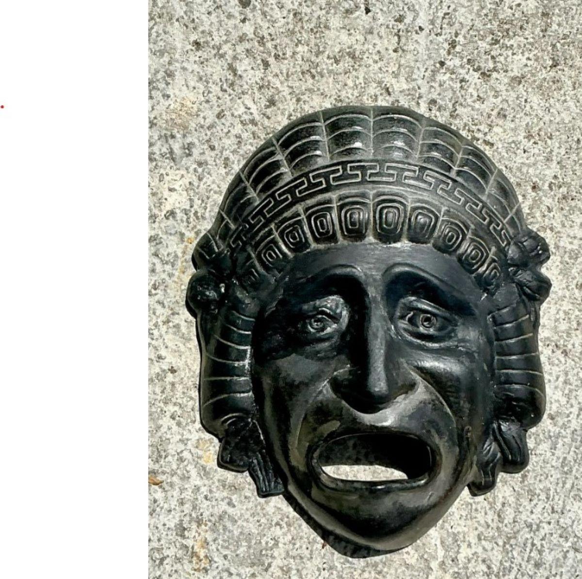 Apportez une touche dramatique et un symbolisme intemporel à votre décoration murale avec cette plaque en terre cuite de la clé grecque vintage. Cette pièce sculpturale expressive représente un visage audacieux et émotif encadré par un motif
