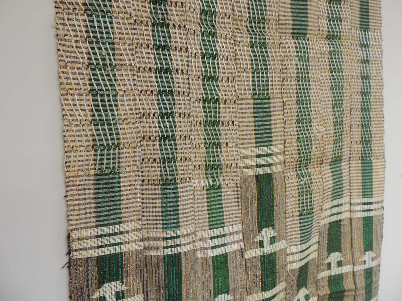 Vintage green and gold Yoruba stripe woven African textile
The Yoruba are highly fashion-conscious people. Colors change from season to season and such non-traditional fibers as Lurex can be introduced into strip woven cloth. A common form of