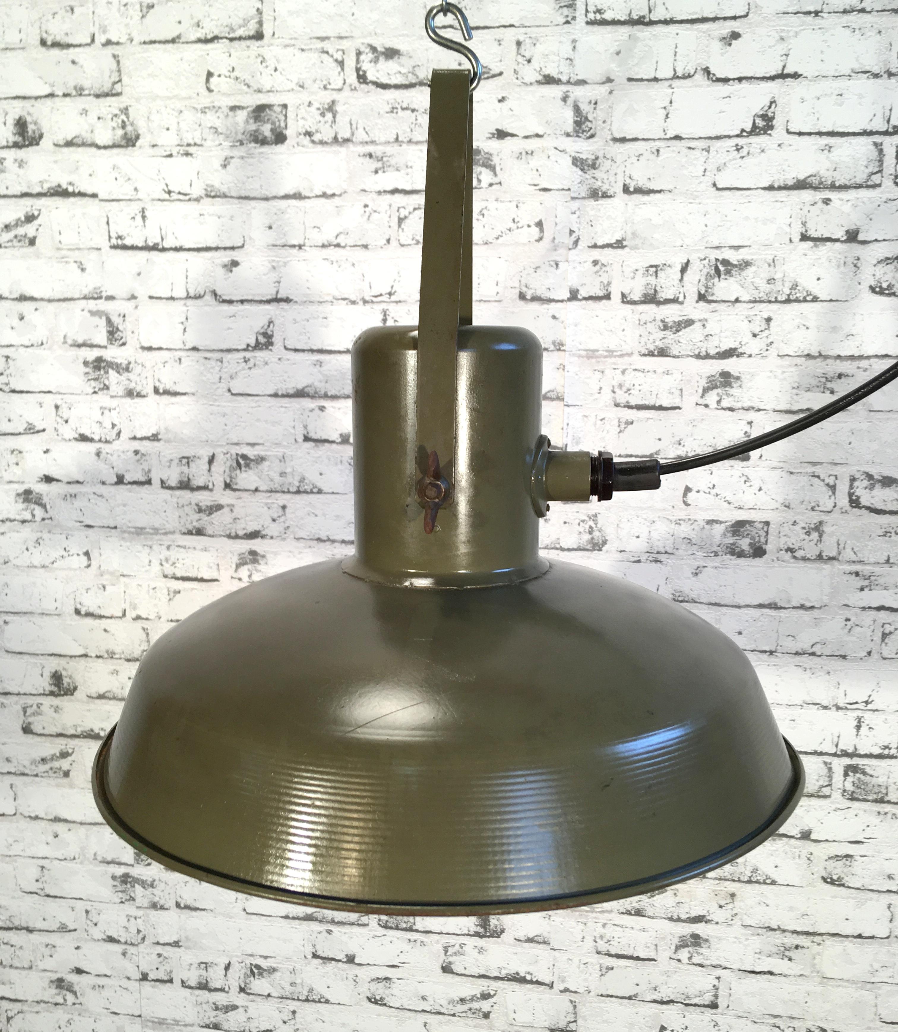 This pendant lamp was made and manufactured in the 1960s for use in the army. It is made from green metal. Lamp is fully functional and holds standard E27 bulbs. Weight of the lamp is 2 kg.