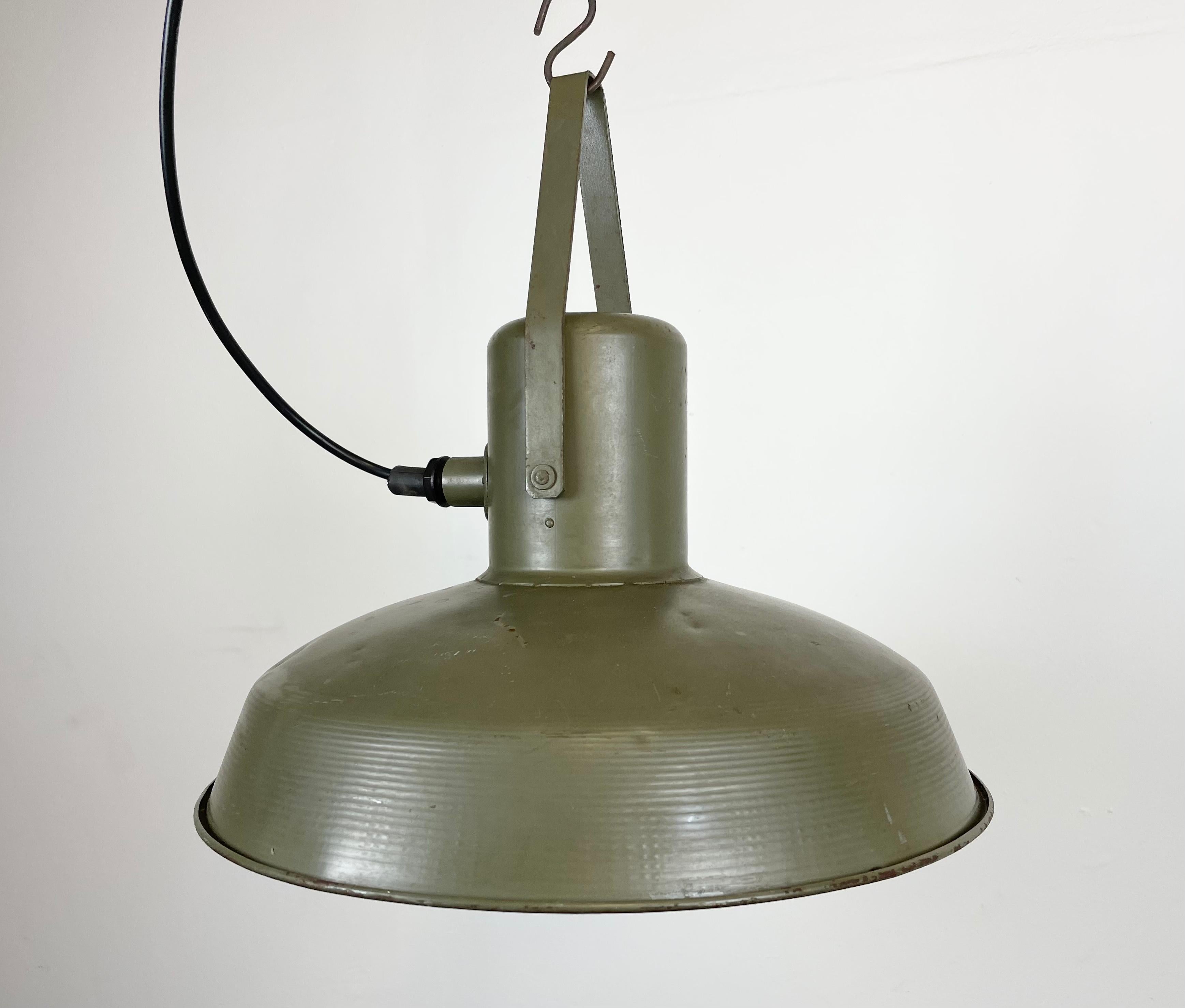 This pendant lamp was made in former Czechoslovakia during the 1960s for use in the army. It is made from green metal. Lamp is fully functional and holds standard E27 light bulbs. The weight of the light is 2 kg.