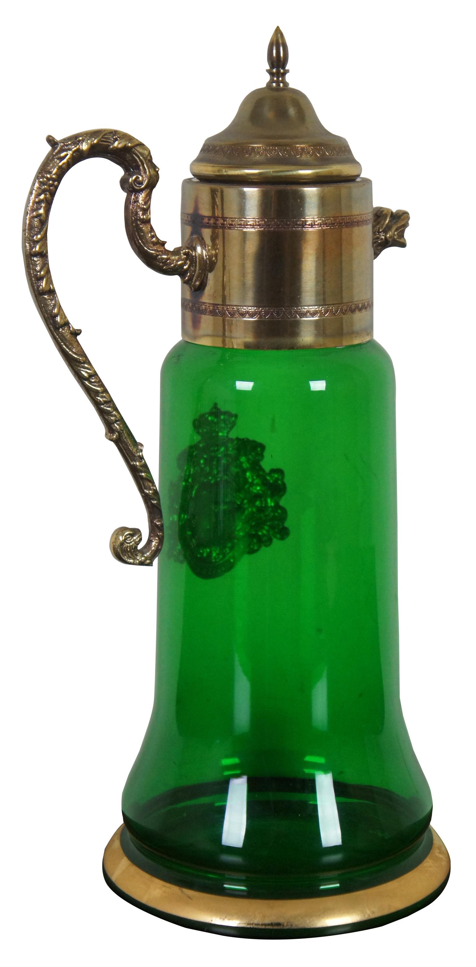 Vintage bohemian green glass pitcher with glass top and handle, griffin shaped spout, and a coat of arms with the motto Spes Ultima Dea (Latin for “Hope is the last goddess.”).
  
