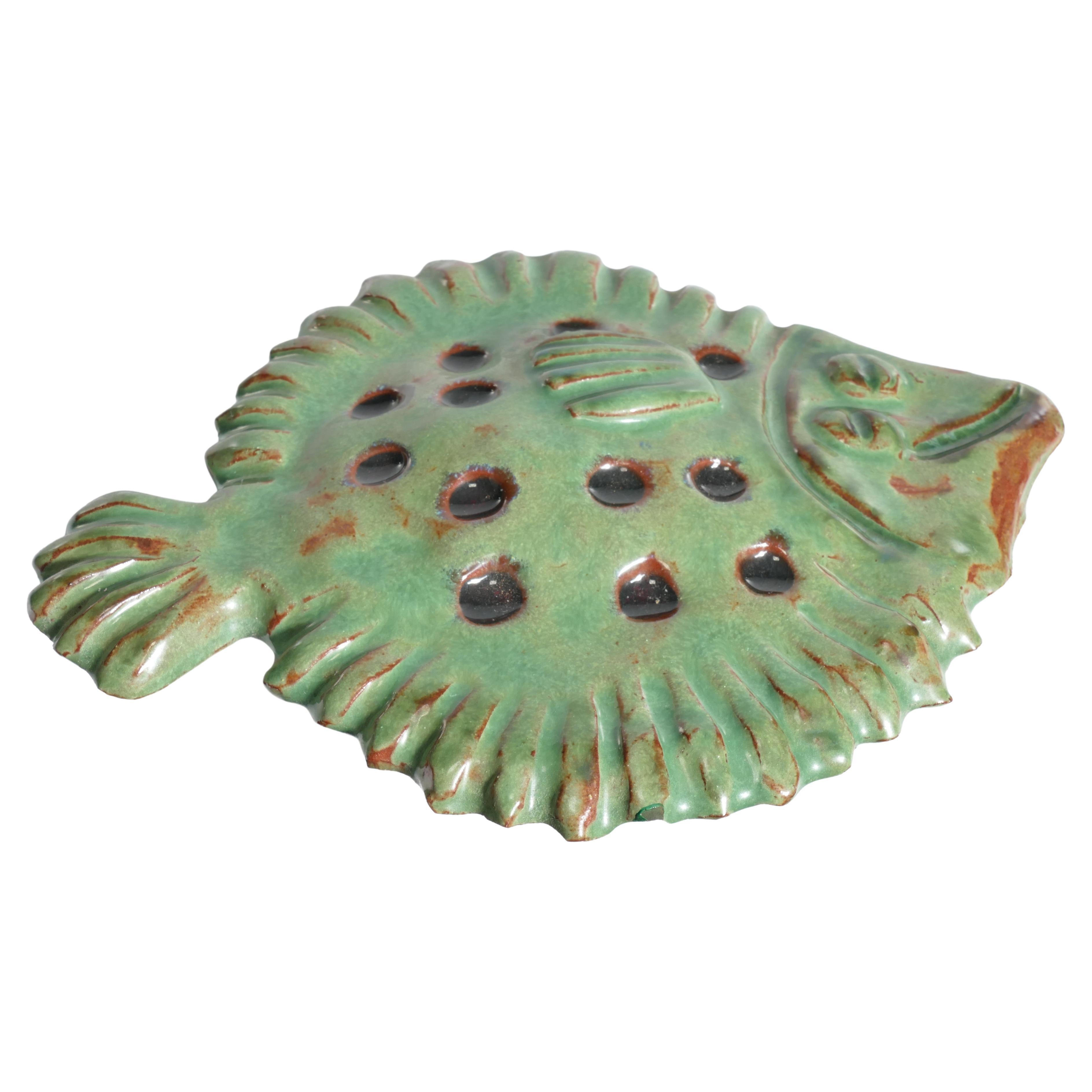 This is a playful and unique vintage green ceramic flounder is handmade by Allan Hellman in Sweden 1967

Allan Hellman (1904-1982) is an ceramic artist hailing from the coastal town Lysekil on the west coast of Sweden. With a passion for clay and a