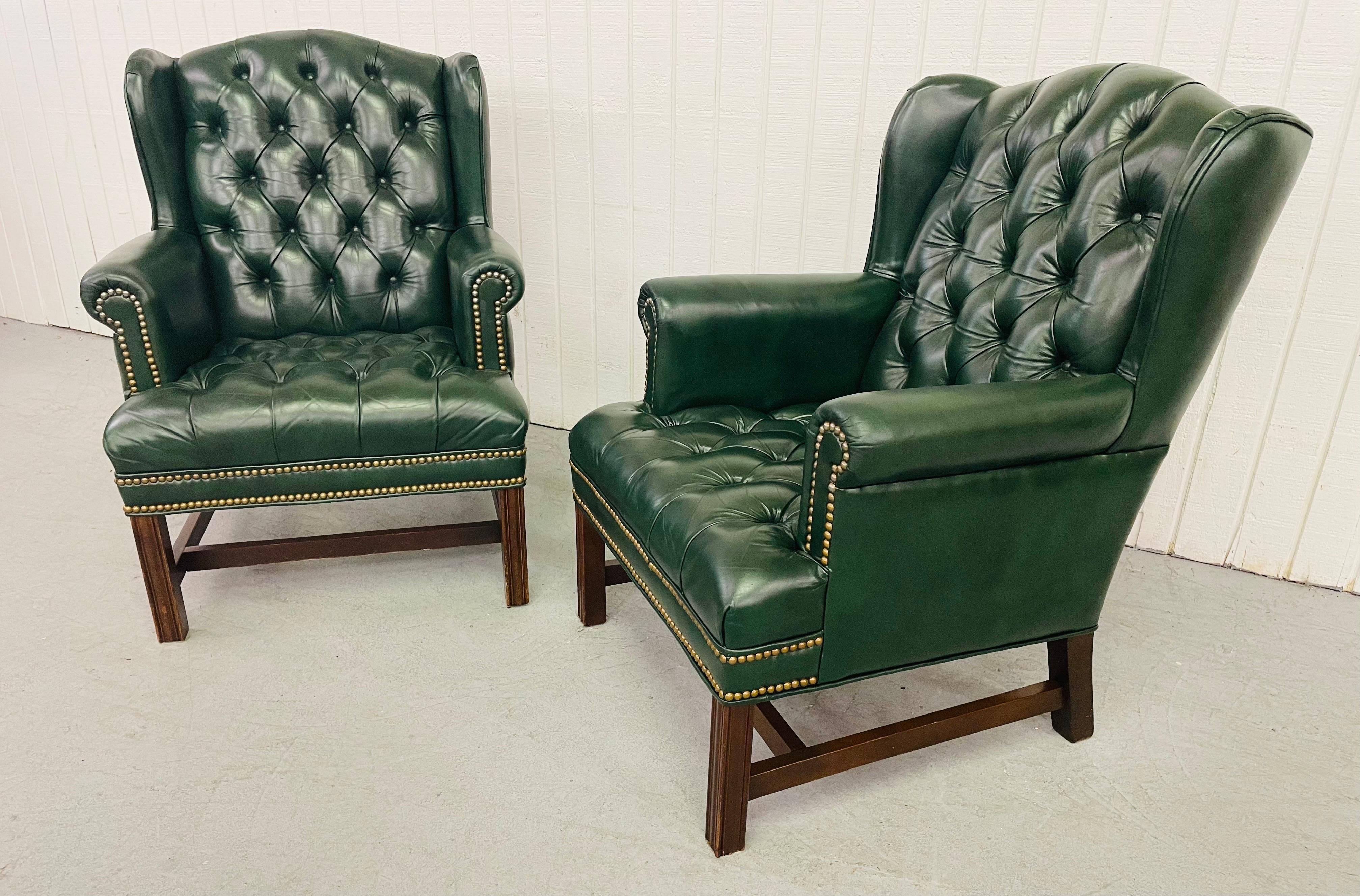 This listing is for a pair of vintage Green Chesterfield Wingback Leather Arm Chairs. Featuring a earthy green leather upholstery, tufted backs and seats, nailhead accents, and mahogany legs.