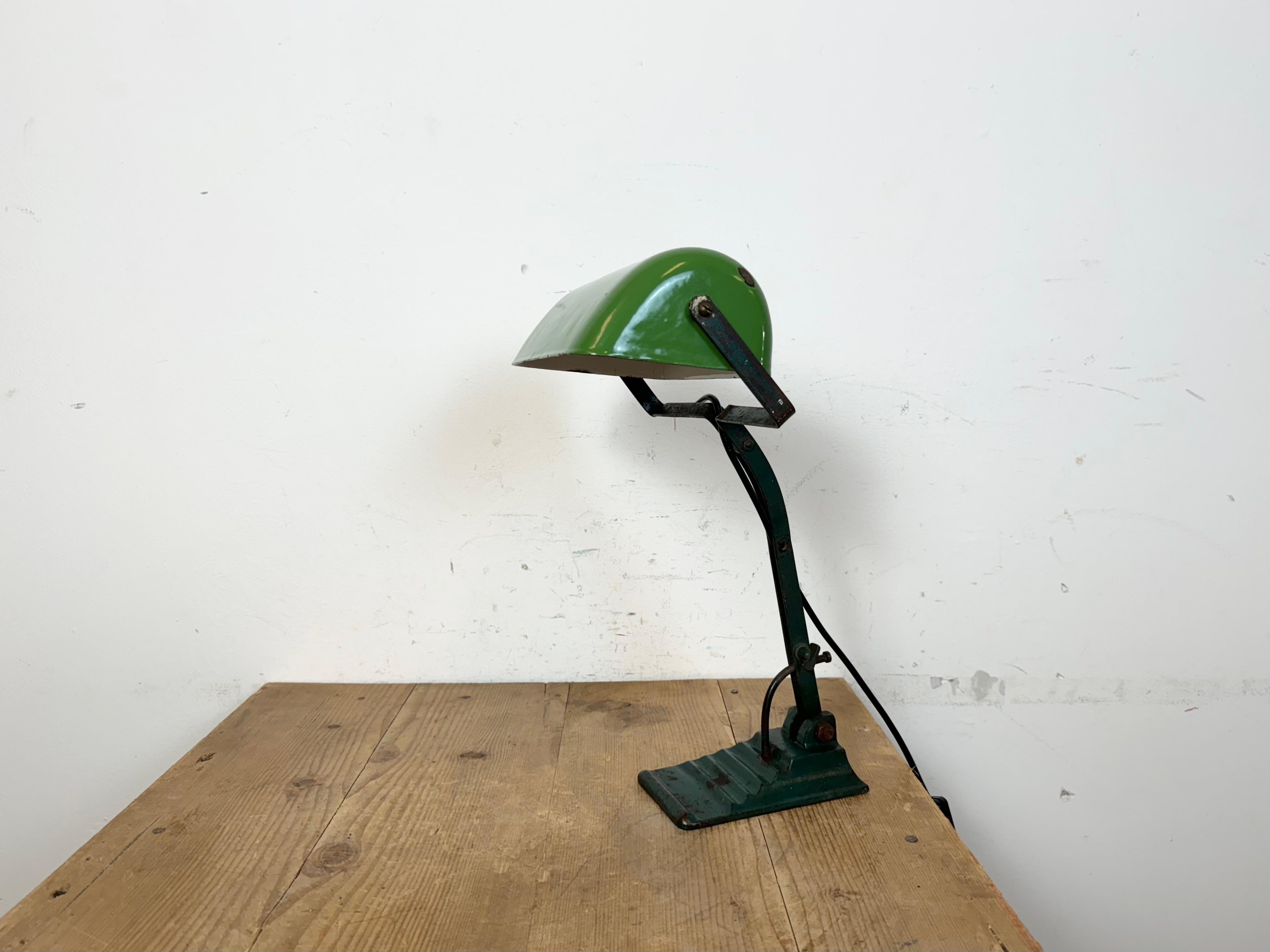 Lampe de table vintage verte fabriquée dans l'ancienne Tchécoslovaquie dans les années 1950. Base en fonte. Abat-jour en fer émaillé vert. Intérieur émaillé blanc. Le bras et l'abat-jour sont réglables. La douille en porcelaine est compatible avec