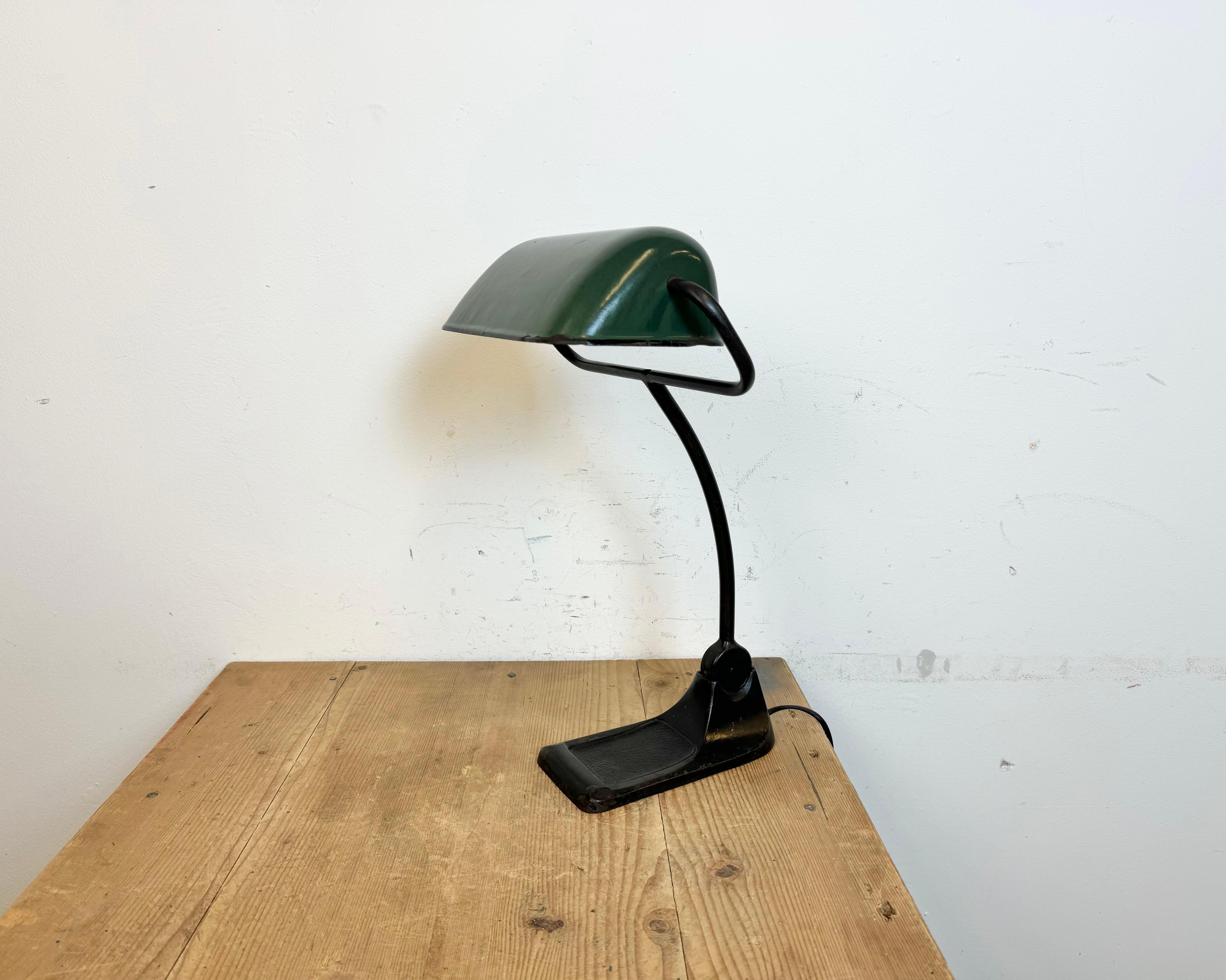 Vintage green enamel bauhaus table lamp made by BUR ( Bünte und Remmler ) in Germany during the 1930s. Cast iron base. Green enameled iron shade. White enameled interior. The arm and shade are adjustable. Porcelain socket requires standard E 27/E26