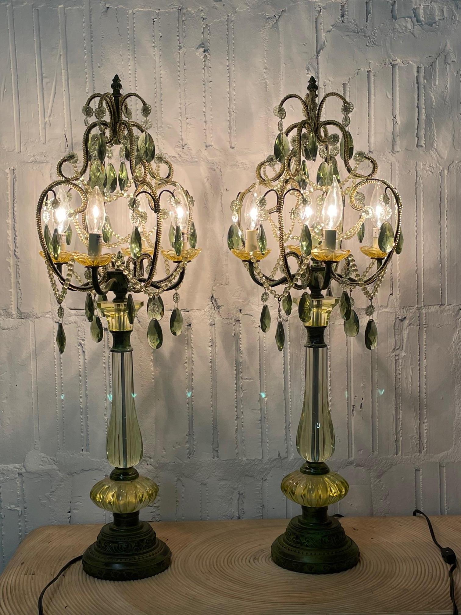Pair of chandelier table lamps feature green glass and green cut crystals. Perfect for your Hollywood Regency decor. Very good condition with only very minor imperfections consistent with age.
