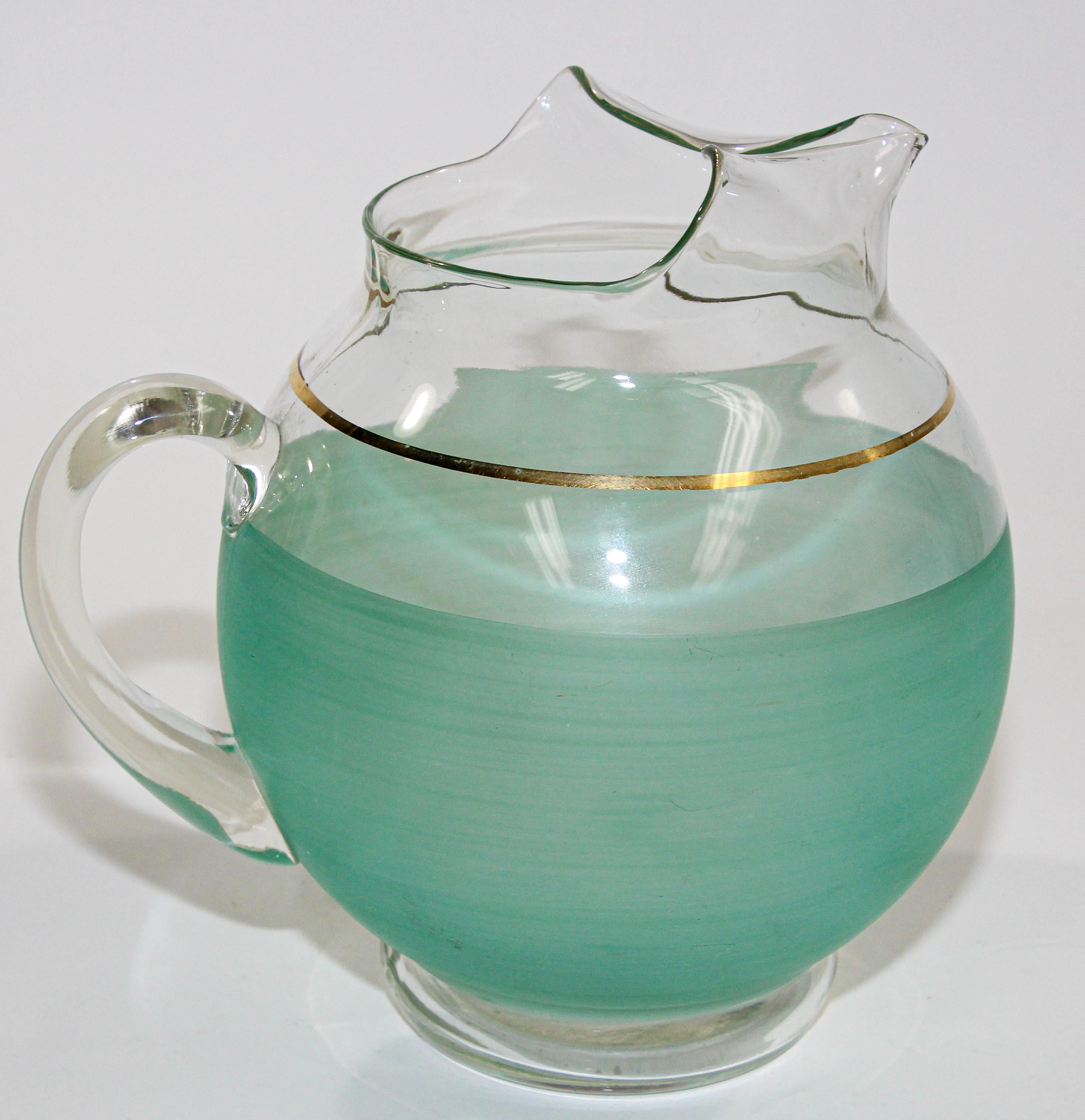 Vintage pastel green glass ware pitcher, American collectible.
1960s Green Glass Pitcher American Collectible Barware.
Gorgeous 1960s Blendo green large pitcher with gold trim, produced by the West Virginia Glass Specialty Company. 
This vintage