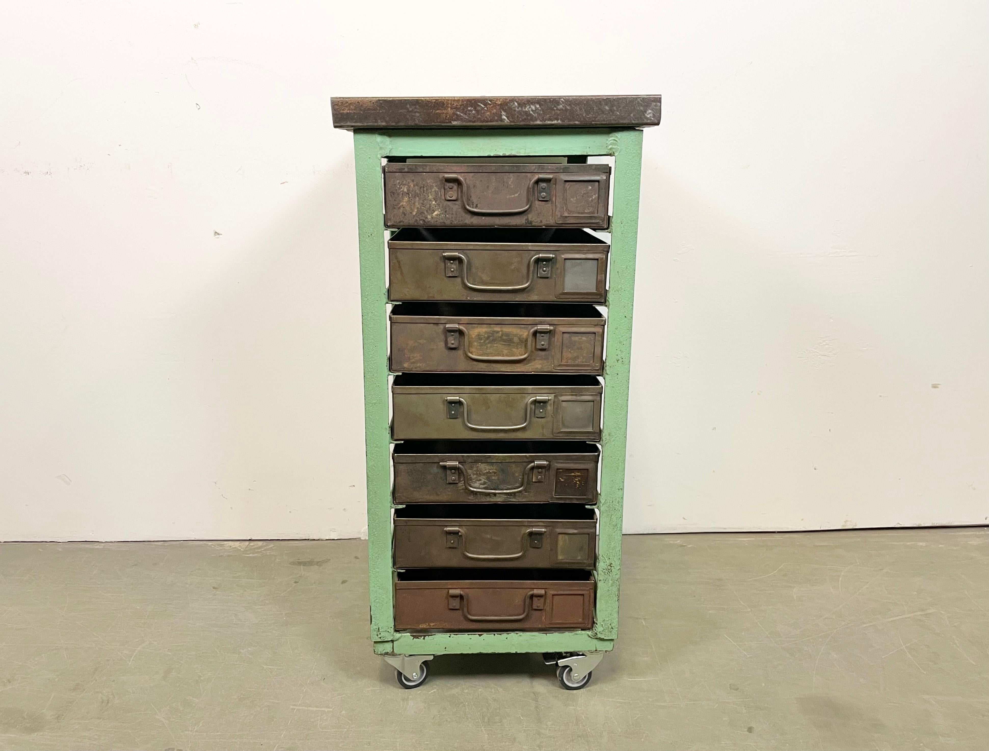 This vintage Industrial iron chest of drawers was made in former Czechoslovakla during the 1950s. It features an iron construction, wooden top and 7 metal drawers. Additional dimensions: 
Drawer dimensions :- Width 28 cm, depth 44 cm, height 8 cm