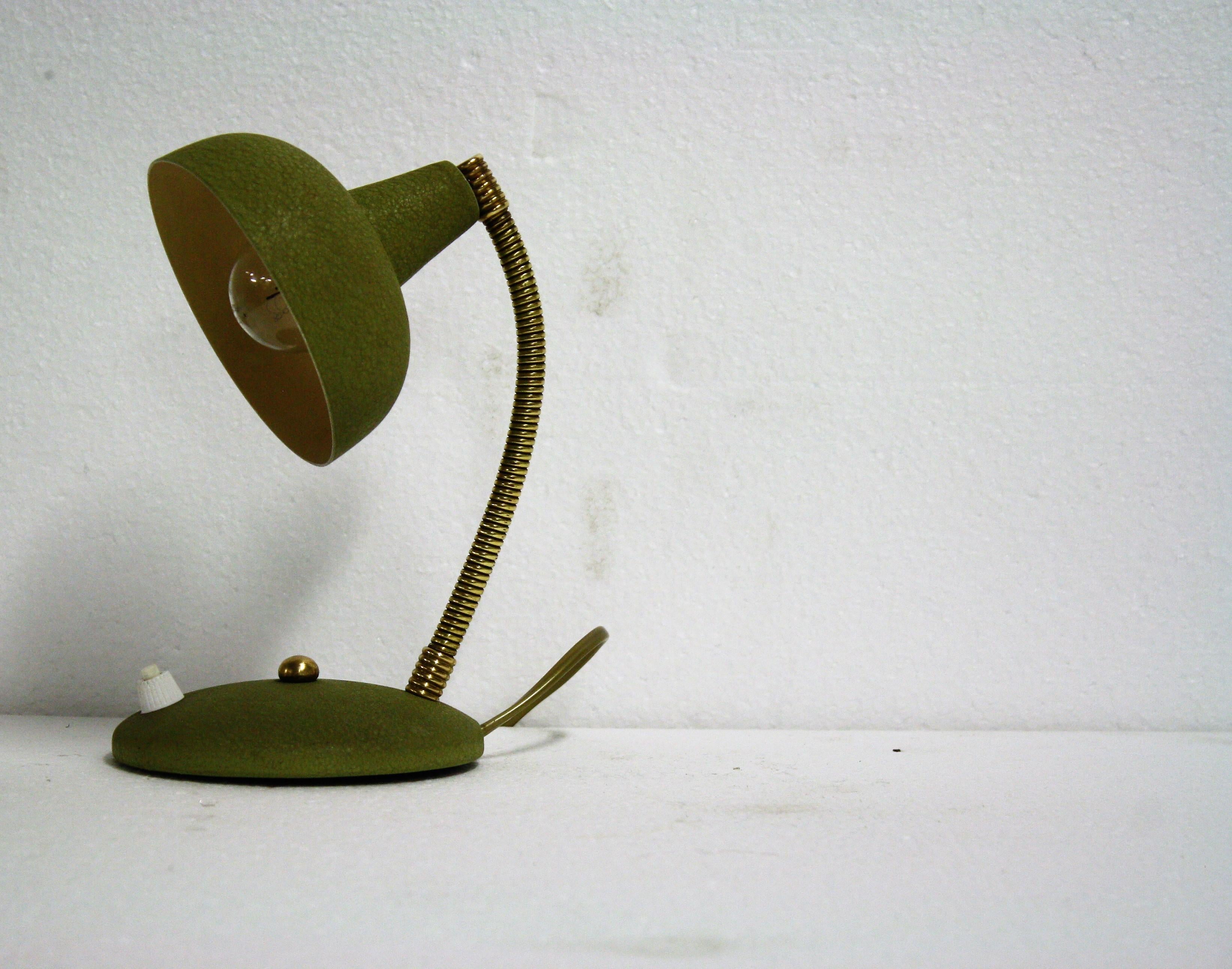 Mid-Century Modern green Italian desk lamp.

This small desk lamp consist of a flexible brass arm with an aluminum shade.

It has a fresh green color which is original from the 1950s.

Rewired, tested and ready to use with a regular E14 light