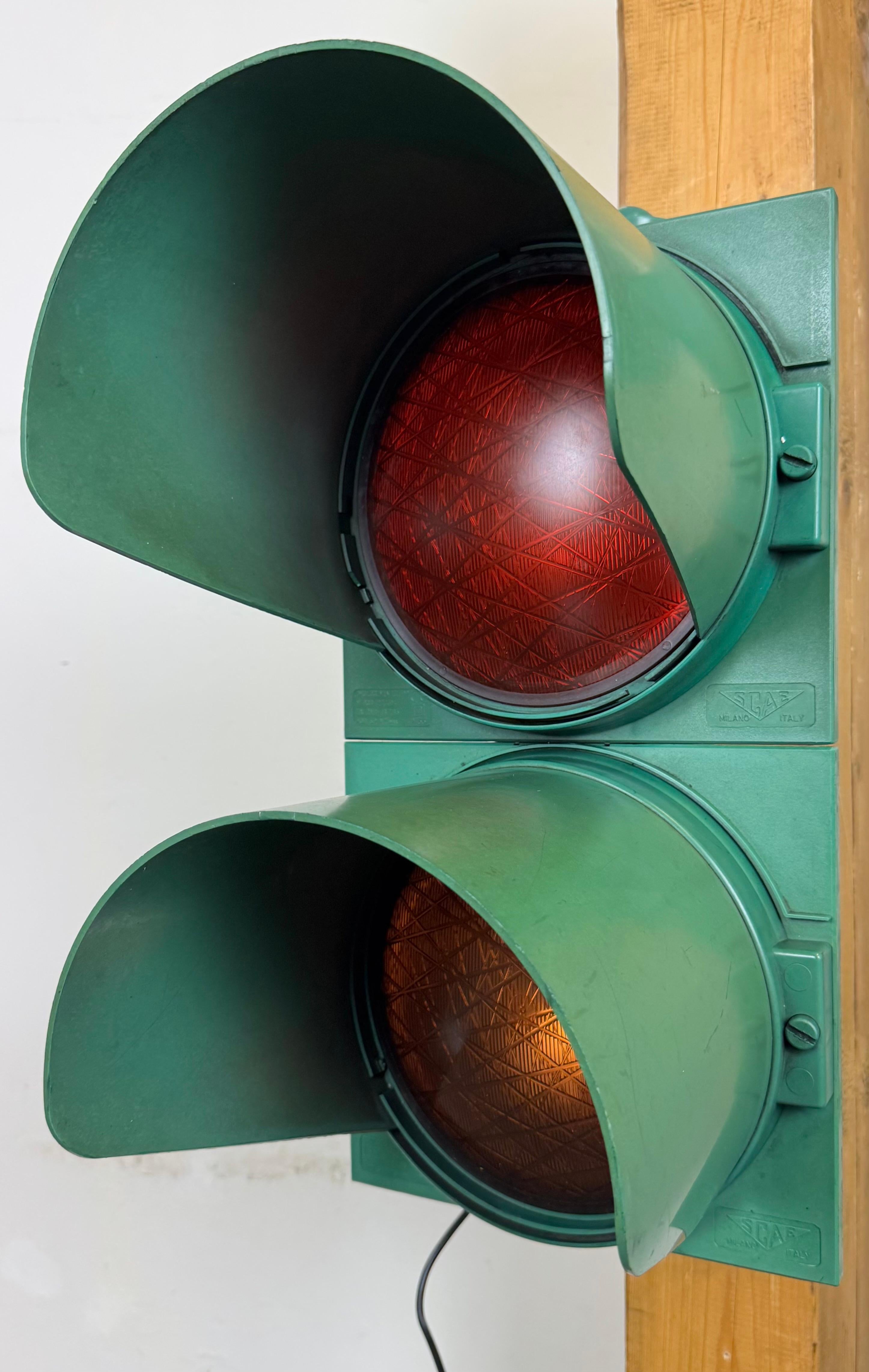 Vintage industrial italian traffic lights made by SCAE Milano in Italy during the 1980s. It features green bakelite body and a red and orange plastic glass covers. The sockets require standard E 27/ E 26 lightbulbs. Rewired to be lit as a lamp or