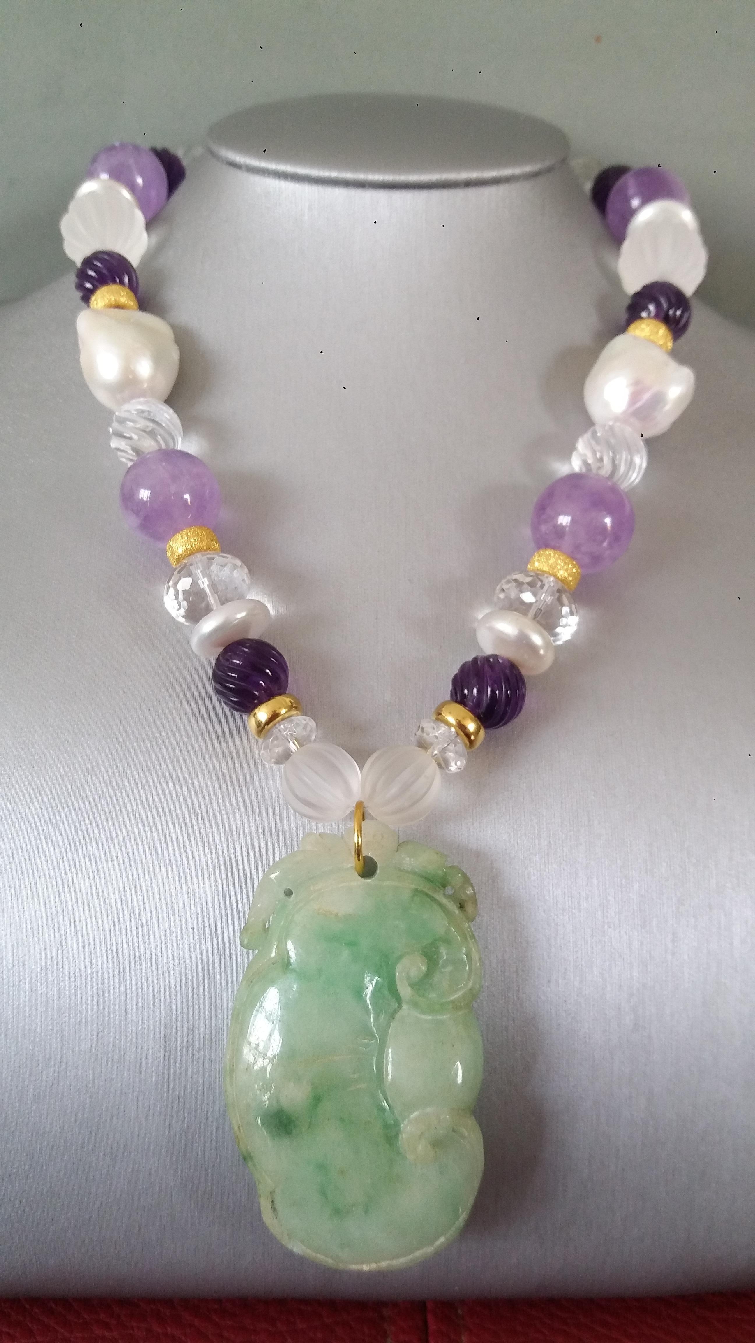 Unique and classic Necklace composed of big size Baroque Pearls, Plain Amethyst spheres of 16 mm, Engraved Amethyst spheres of 12 mm, Faceted and Engraved Quartz beads, 14 kt Yellow Gold elements, from which hangs a Vintage Green Burma Jade