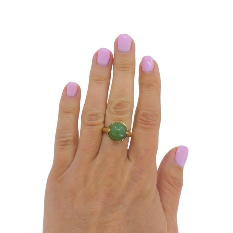 A vintage green jade ring made of 14k gold.  A smooth, cone shaped jade is bezel set. The shank is smooth and sleek to complement the stone. The overall design is clean and balanced, making the jade the focal point. This minimal design allows to fit
