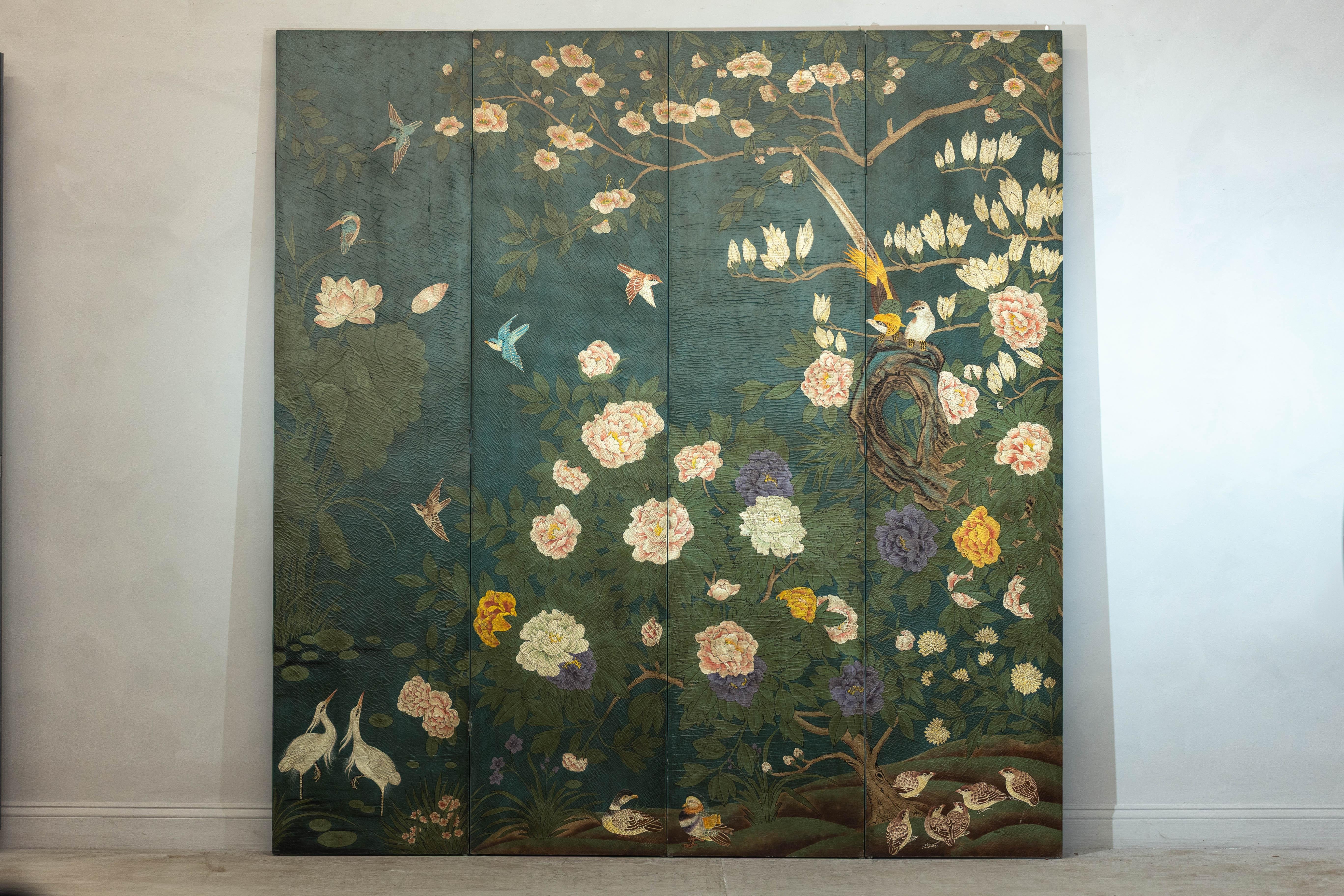 A four-panel screen, hand-painted with a lush botanical scene set against a deep green backdrop. Delicate birds in flight, blooming peonies, and trailing branches create a captivating composition, framed by finely detailed foliage. The painterly