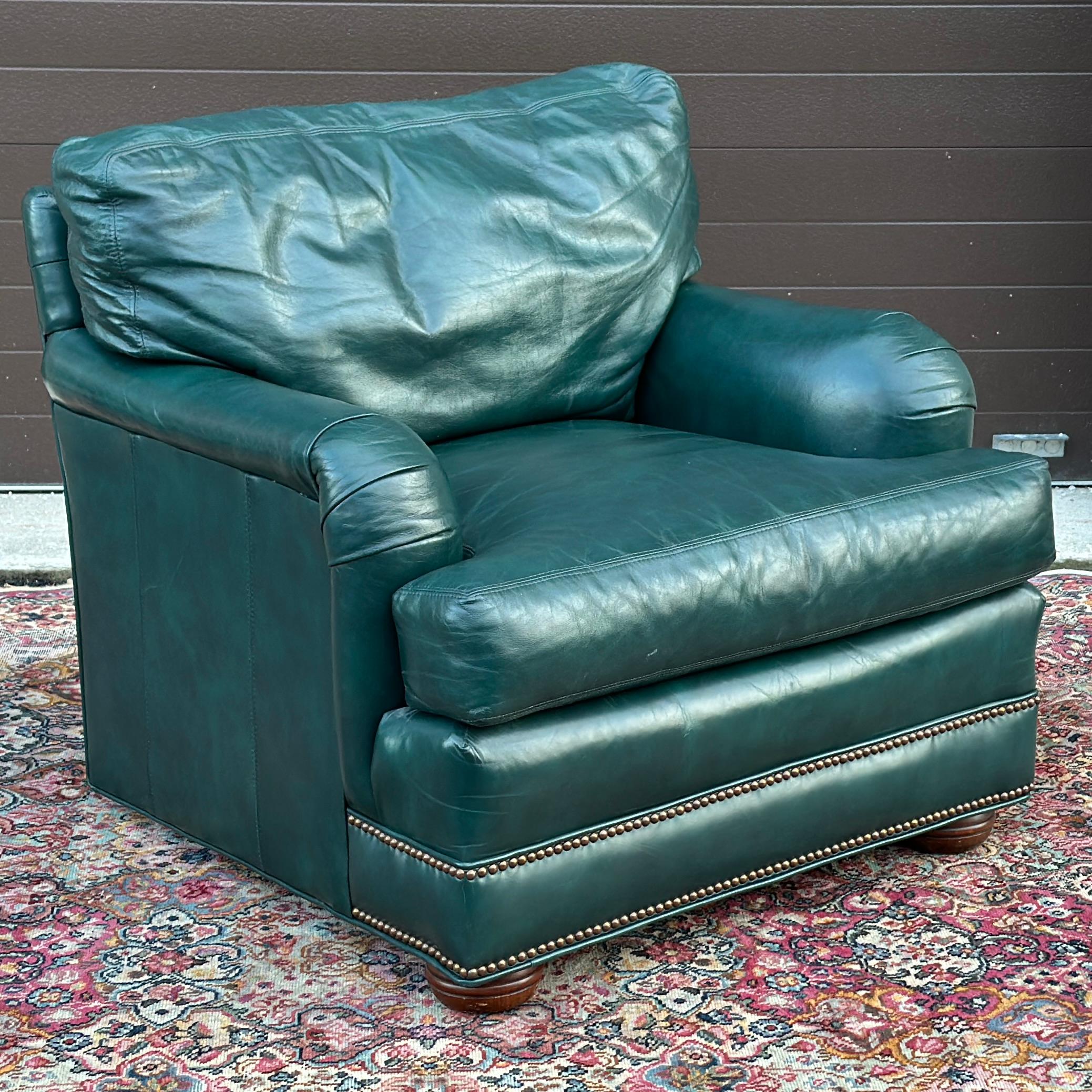 Vintage Green Leather Lounge Chair With Brass Tack Trim by Hickorycraft with wooden bun feet in the front and square wooden back feet that are hidden. Matching ottoman and loveseat available at time of listing! 