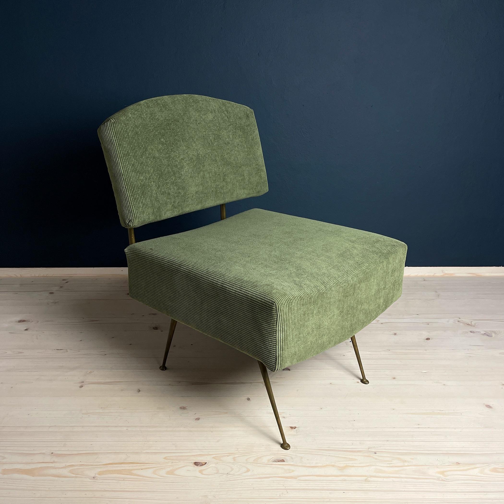 Introducing a magnificent vintage lounge chair, hailing from Italy in the 1950s. This exquisite piece of Italian furniture exudes an air of timeless charm, combining a touch of mid-century style with the comforts of home. The chair's green corduroy