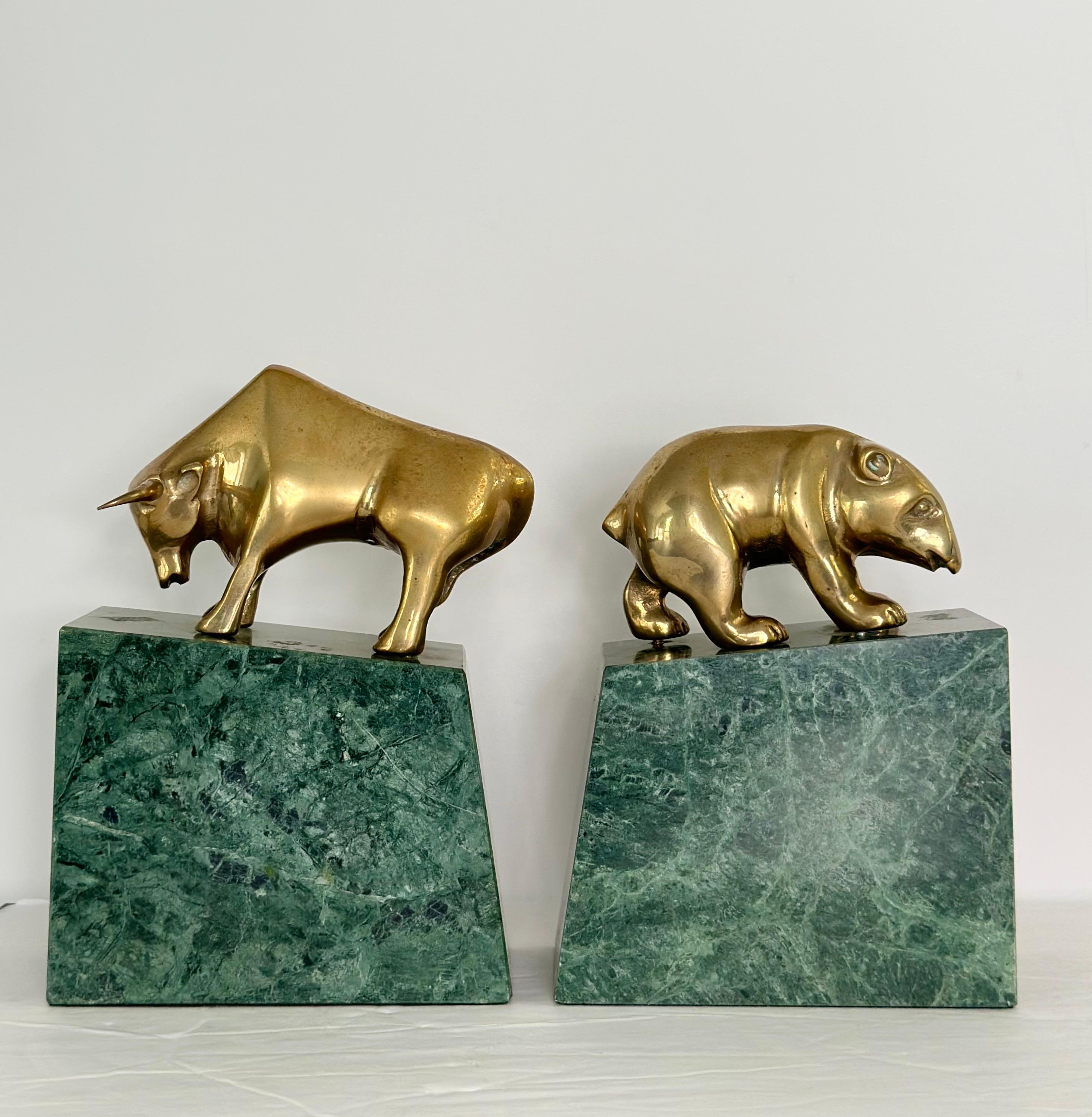 Wir freuen uns sehr, Ihnen ein raffiniertes Paar Buchstützen anbieten zu können, das den ikonischen Bullen und den Bären der Wall Street aus den 1980er Jahren zeigt.  Jede Buchstütze zeigt eine schön gearbeitete Messingfigur auf einem Sockel aus