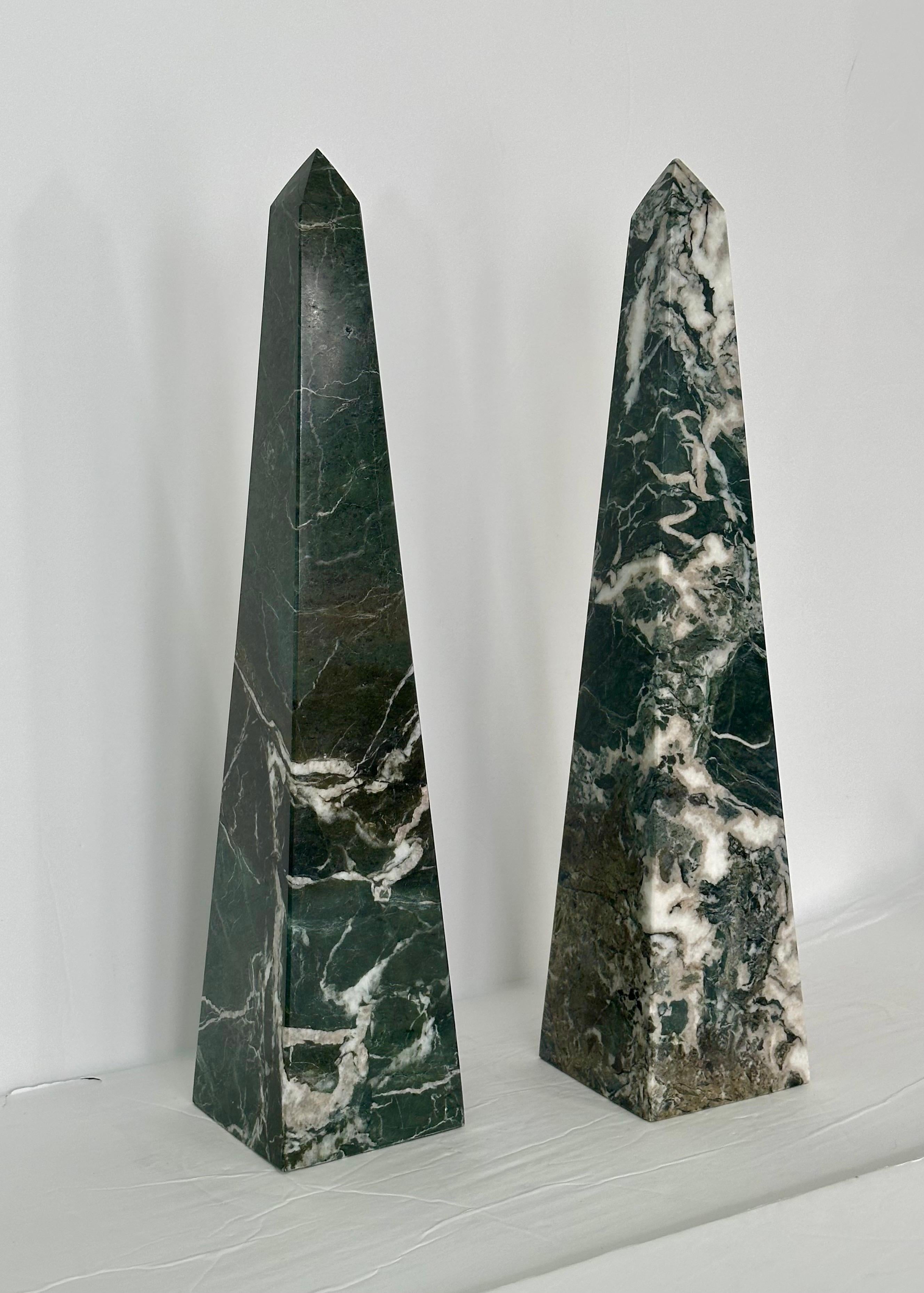 We are very pleased to offer a pair of beautiful stone obelisks, circa the 1970s.  Carved from fine marble, these obelisks boast a mesmerizing color palette that includes shades of green, white, and grey.  The vivid colors are accompanied by