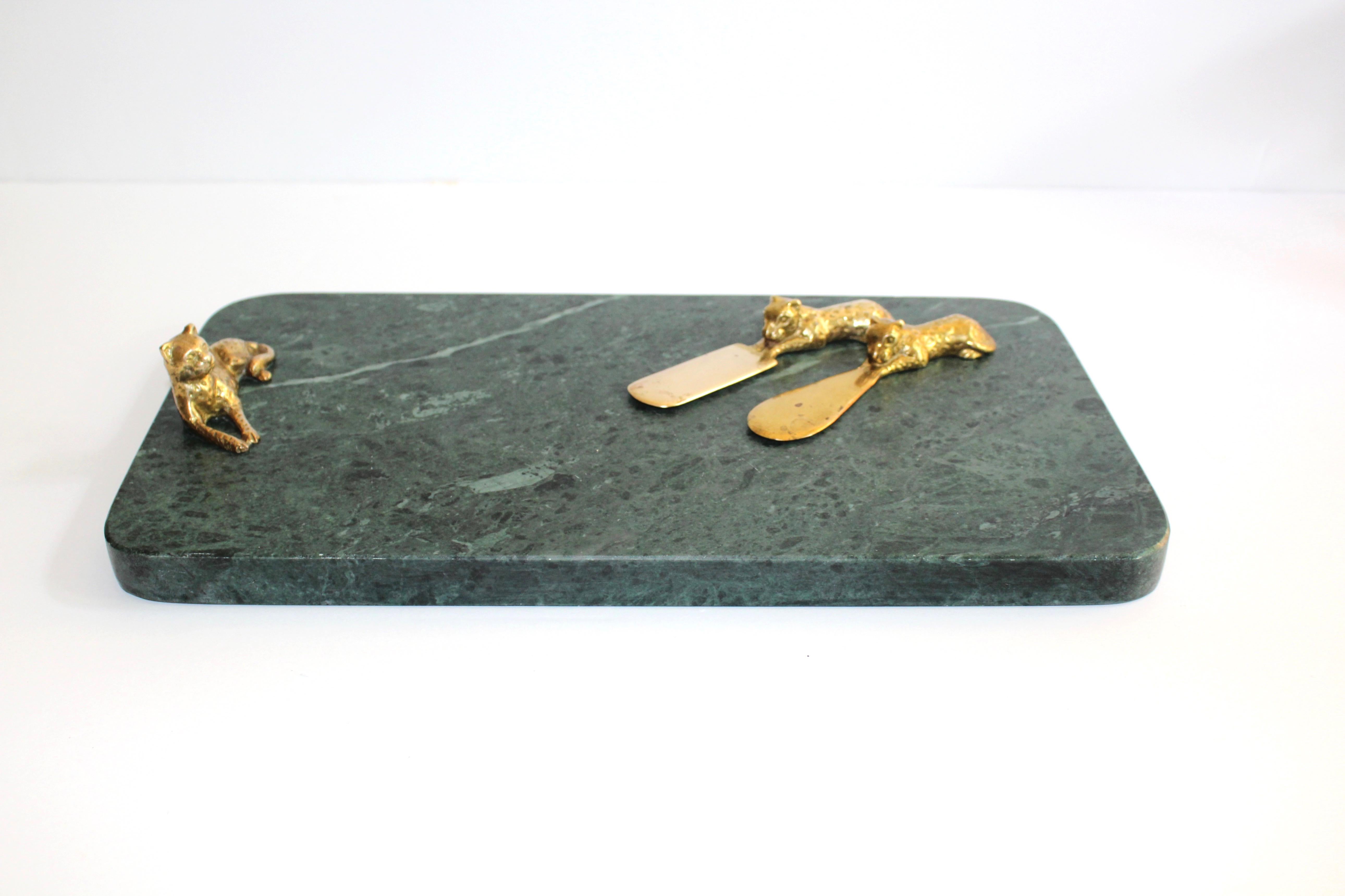 Mid-Century Modern serving tray and cheese board in gorgeous dark green marble. Natural stone with rich veins of dark green colors and textures, features a resting leopard handle in gold plated brass as well as two leopard serving knives. Rectangle