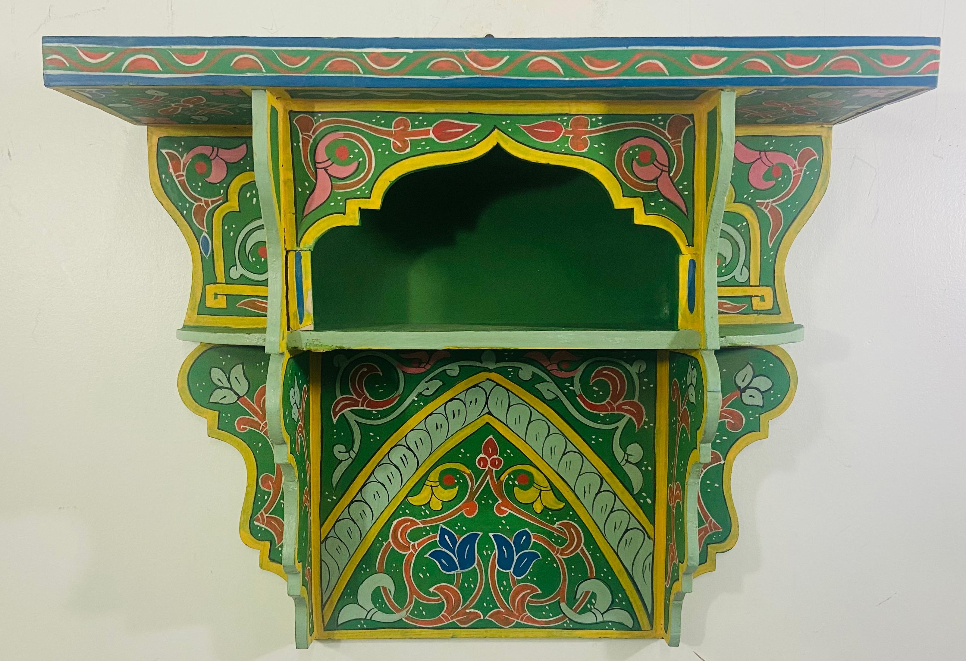 A stunning pair of vintage hand painted Moroccan spice shelves or racks. The shelves are finely hand painted featuring fine moorish and arabesque motifs, painted in Green and decorated with multicolor designs. Each rack has two shelves , top and