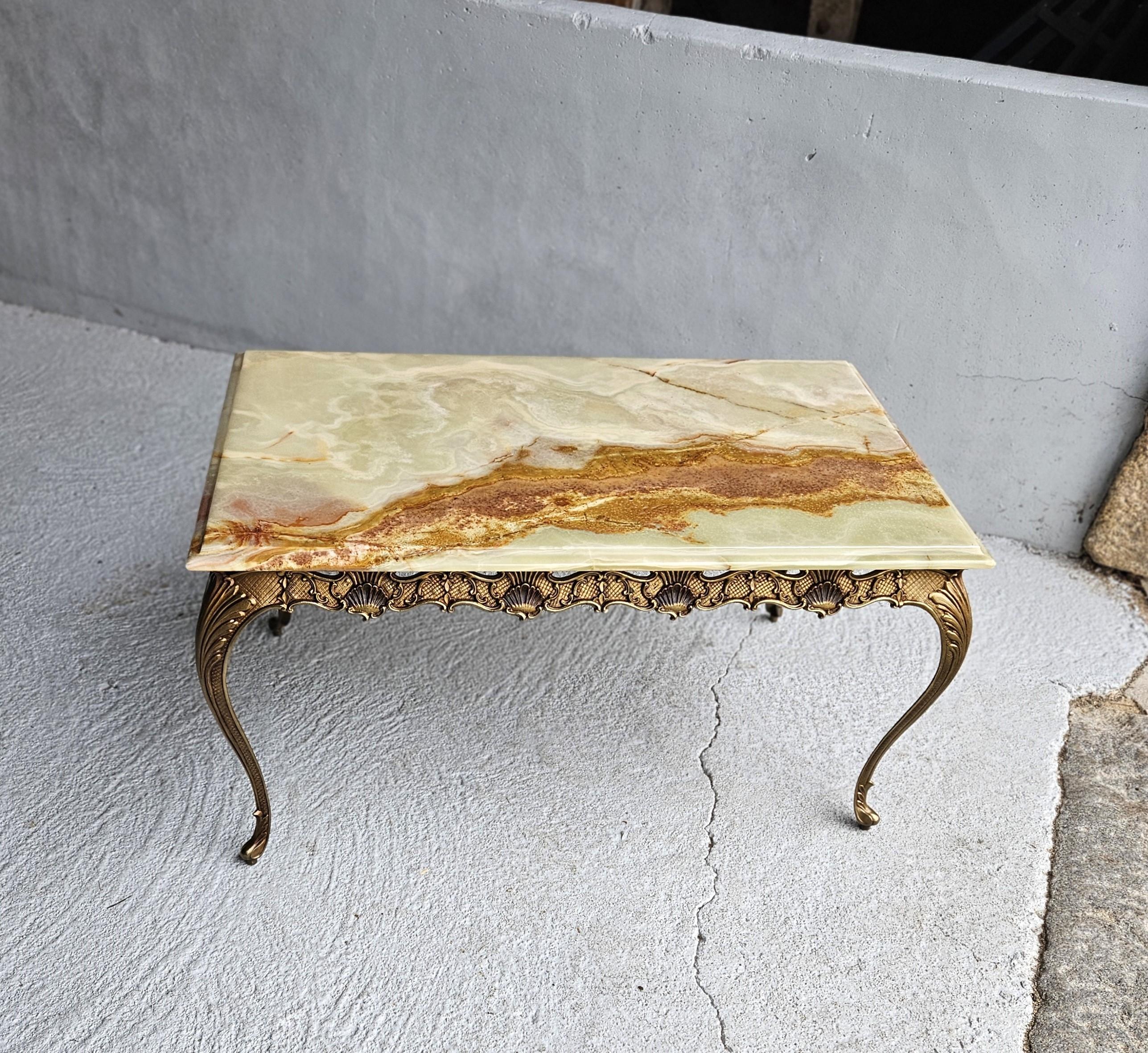 Discover the elegance of the 1970s with this French Vintage rectangular coffee table, featuring a green Onyx Marble Top and Bronze Frame in the Louis XV Style. 
The Tabletop boasts a refined Shape and is adorned with natural patterns, showcasing a