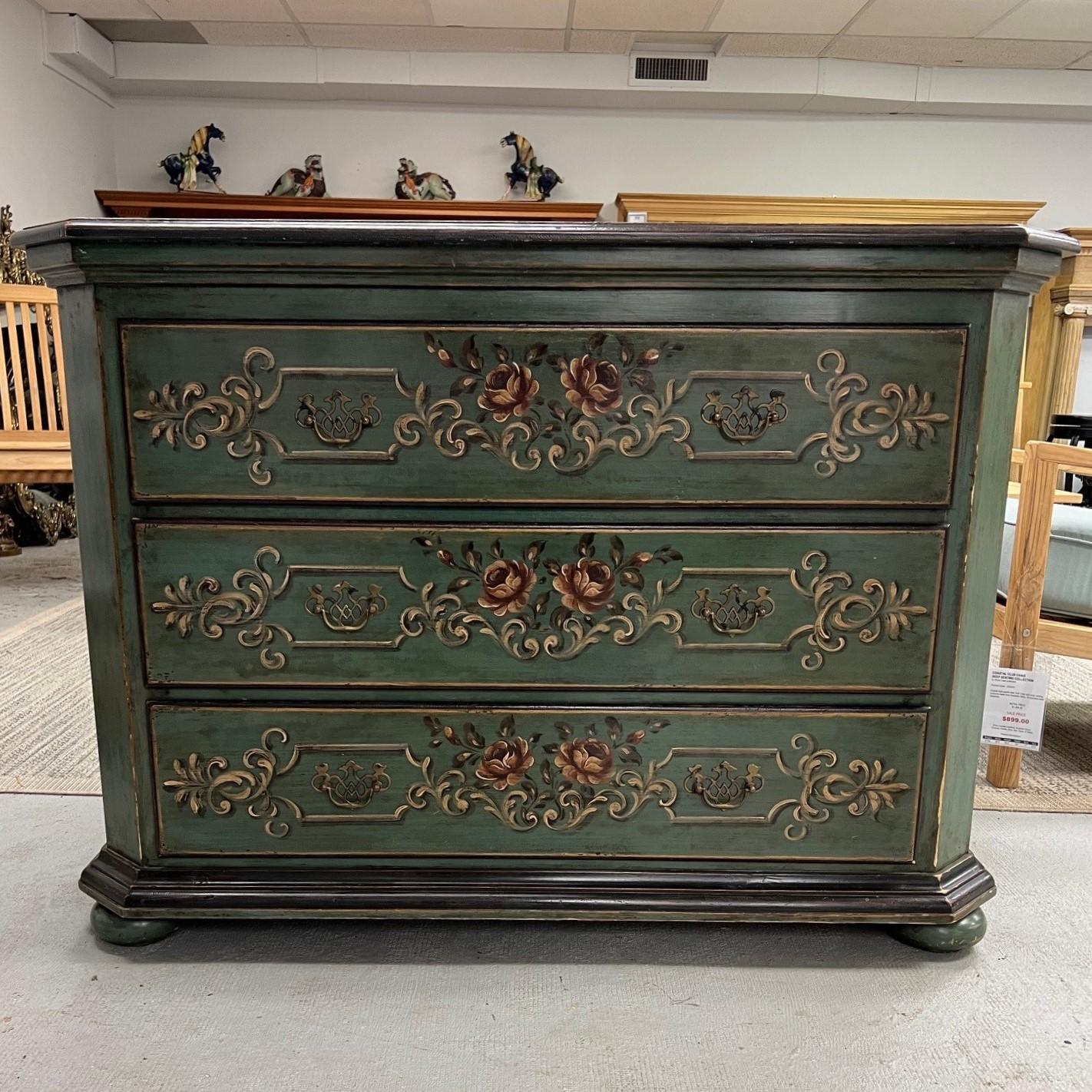 Si tratta di un'attraente cassettiera a tre cassetti o commode italiana con una bellissima finitura dipinta. La cassettiera ha una finitura verde vintage con fiori e volute dipinte a mano sui cassetti. Ha un timbro sul retro Made in Italy e nel
