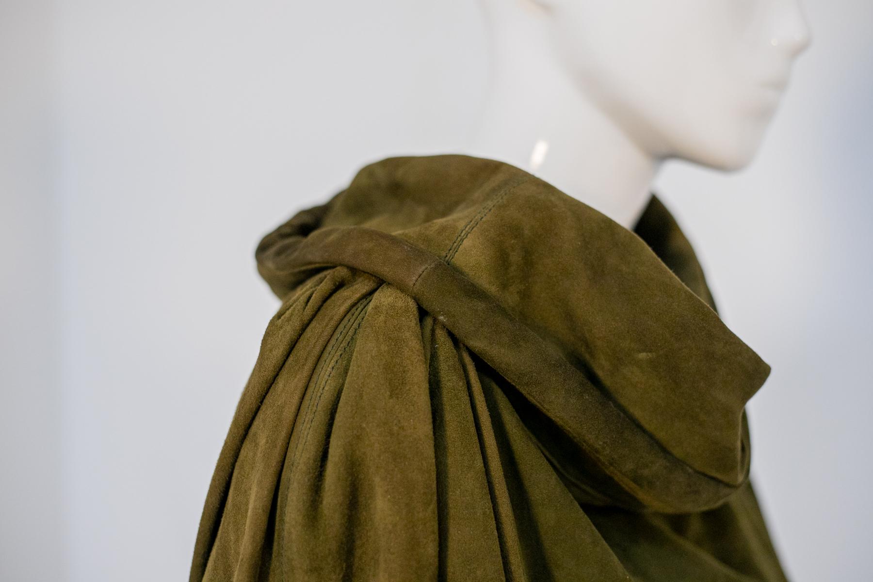 Besonderer Vintage-Mantel aus den 1990er Jahren, hergestellt in Italien.
Der Mantel ist ganz aus sehr schönem und elegantem olivgrünem Wildleder, mit sehr weichen langen Ärmeln.
Der Kragen ist das Highlight des Mantels: Er hat nämlich nicht den