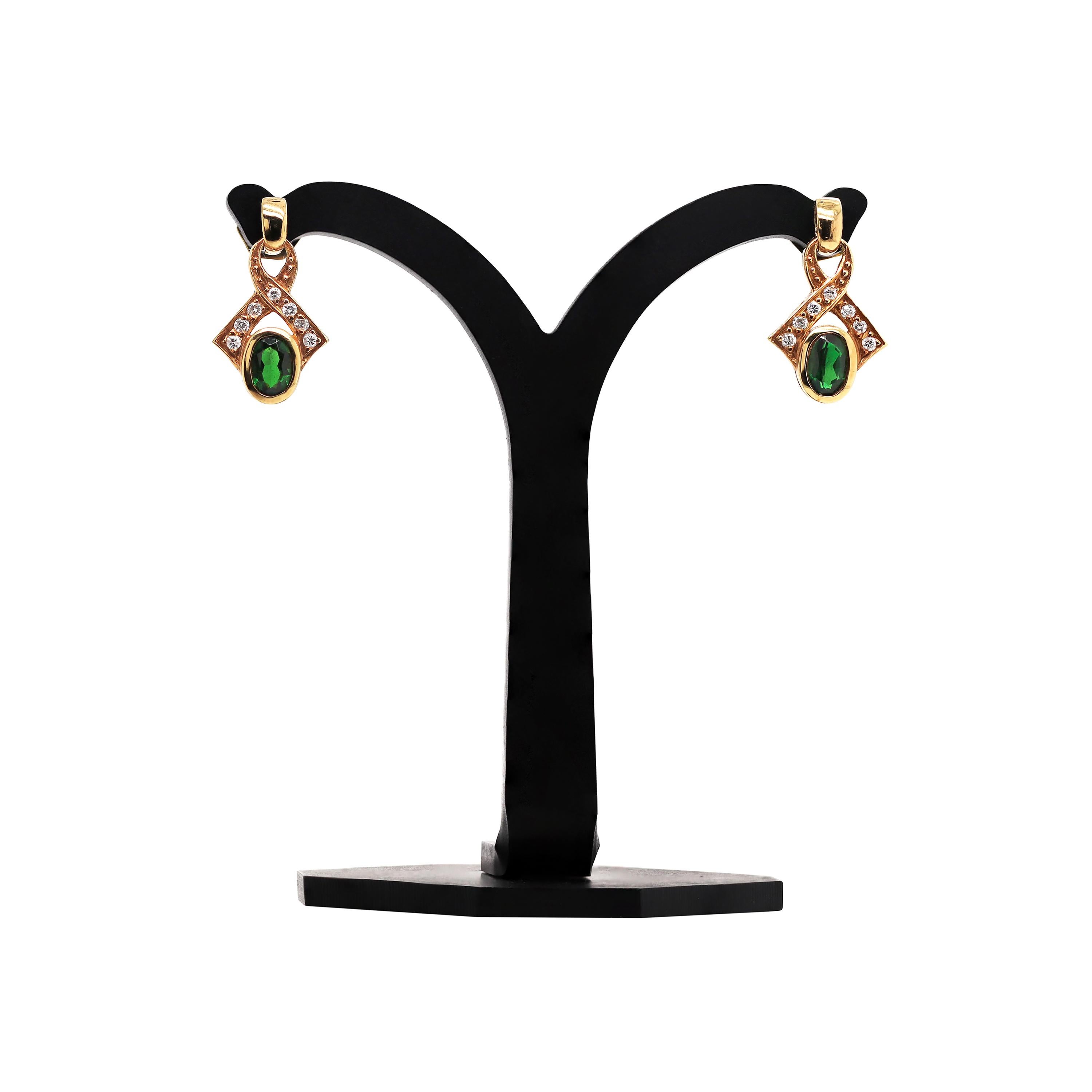 These lovely vintage earrings feature 7 round brilliant cut diamonds mounted on a twisted dangle ribbon, suspended from an elongated screw-back stud, weighing a total approximate weight of 0.24ct. A beautiful 4x6mm rubover set green tourmaline, with