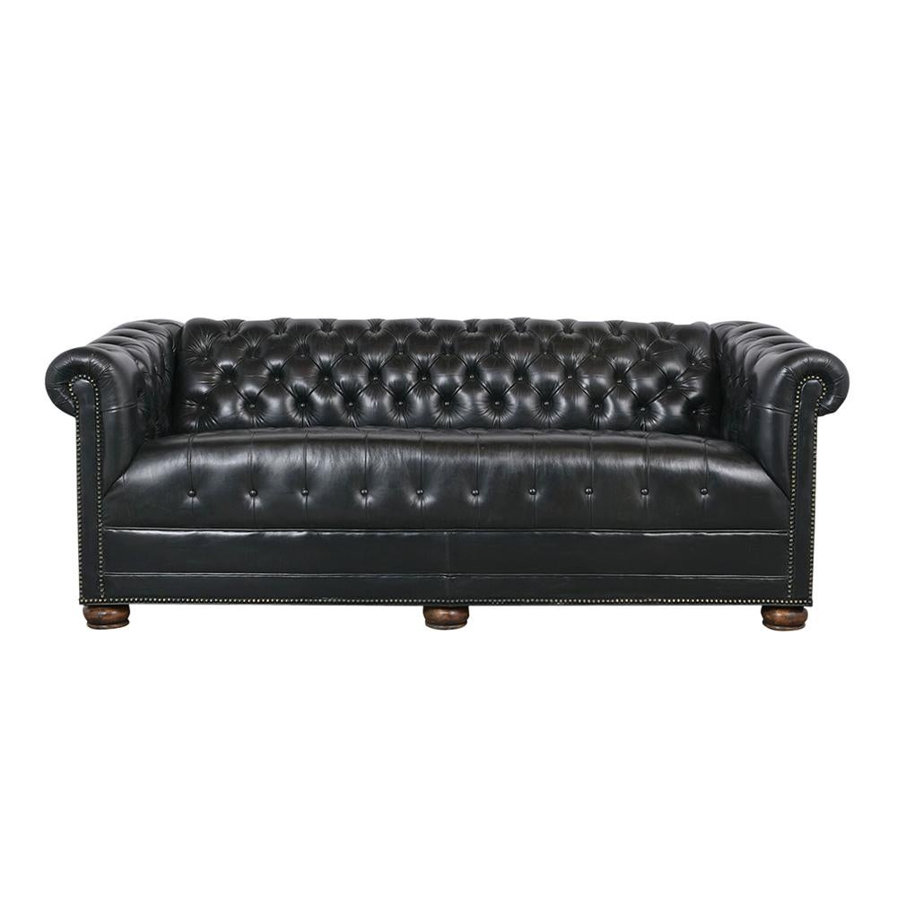 This 1960s Chesterfield-style sofa is upholstered in the original dark green leather and features tufted details on the seat back & scrolls arms with brass nail details. This sofa also features comfortable seats,  coil springs for added comfort, and