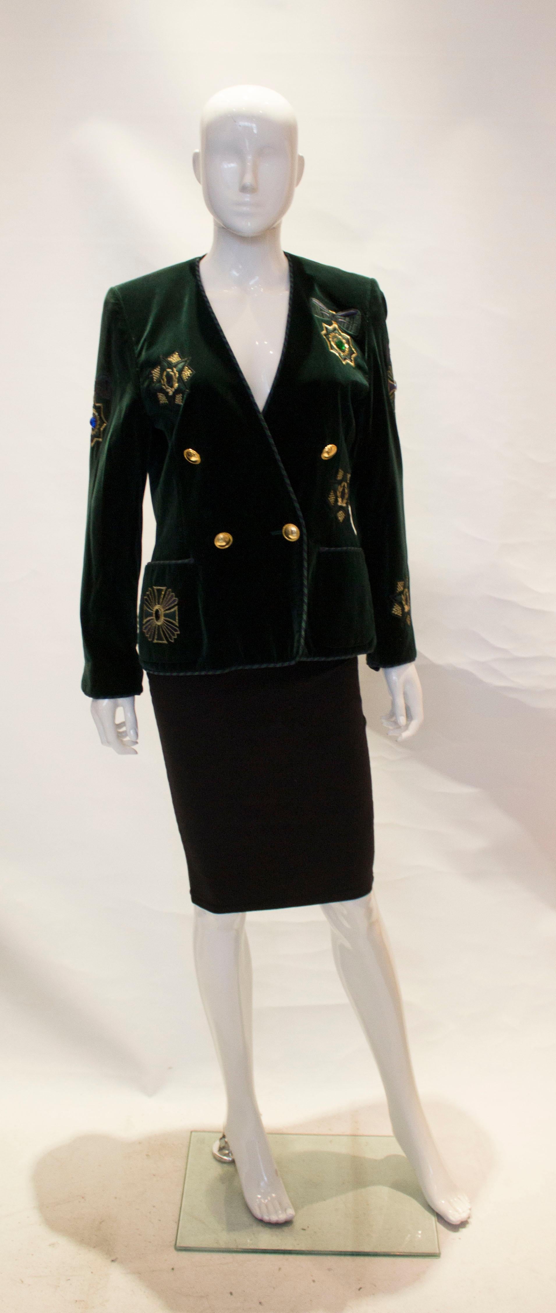 A stunning vintage green velvet jacket by  Escada. The jacket is in a wonderful green with embellishment, and stripe braid detail. It is double breasted, with two front pockets and three button cuffs.