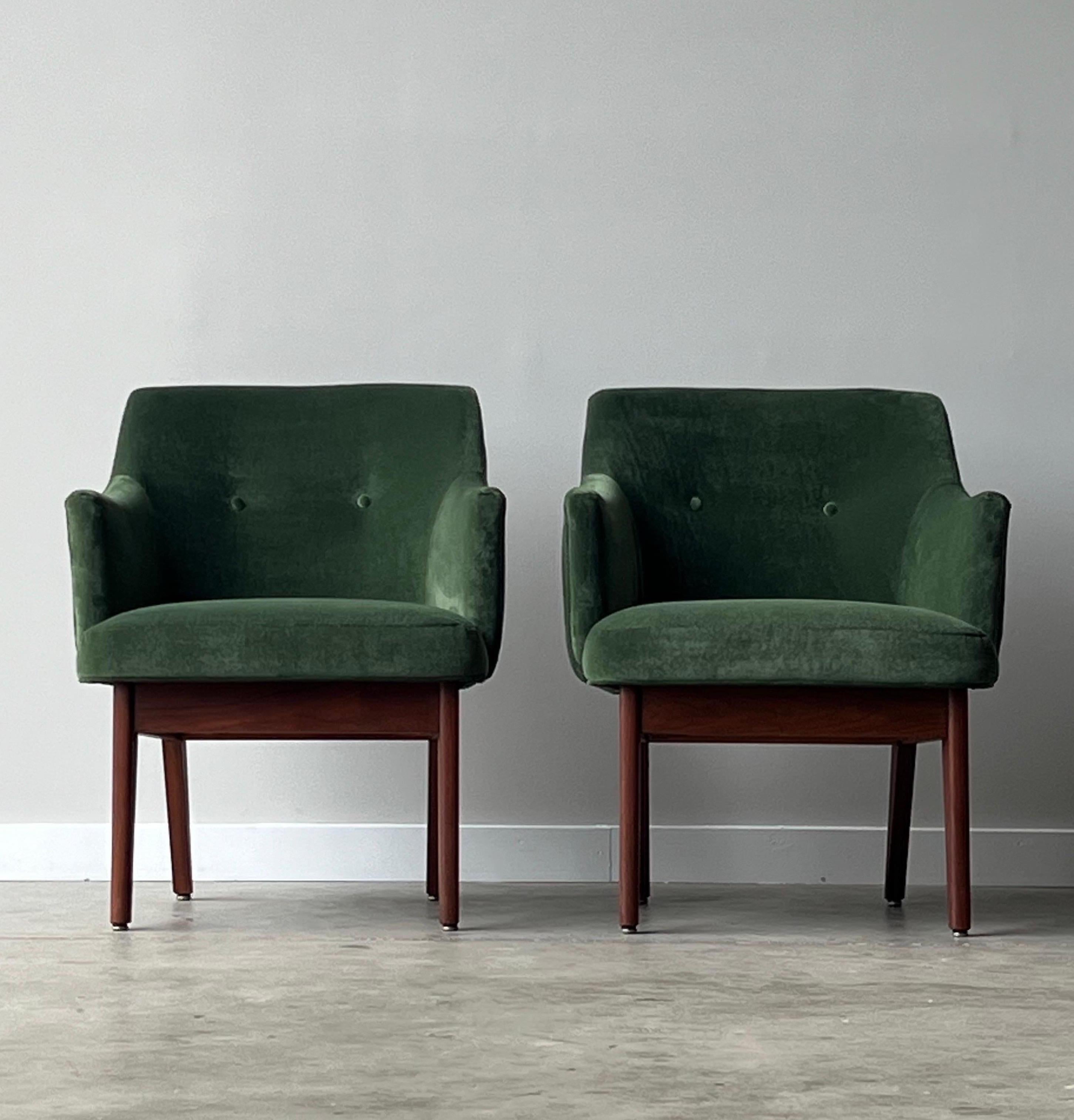 Mid-century pair of lounges in the style of Adrian Pearsall. This pair has been newly reupholstered in a forest green soft velvet fabric with two accent buttons on the backrest. They sit on a walnut base with tapered walnut legs. The back legs are