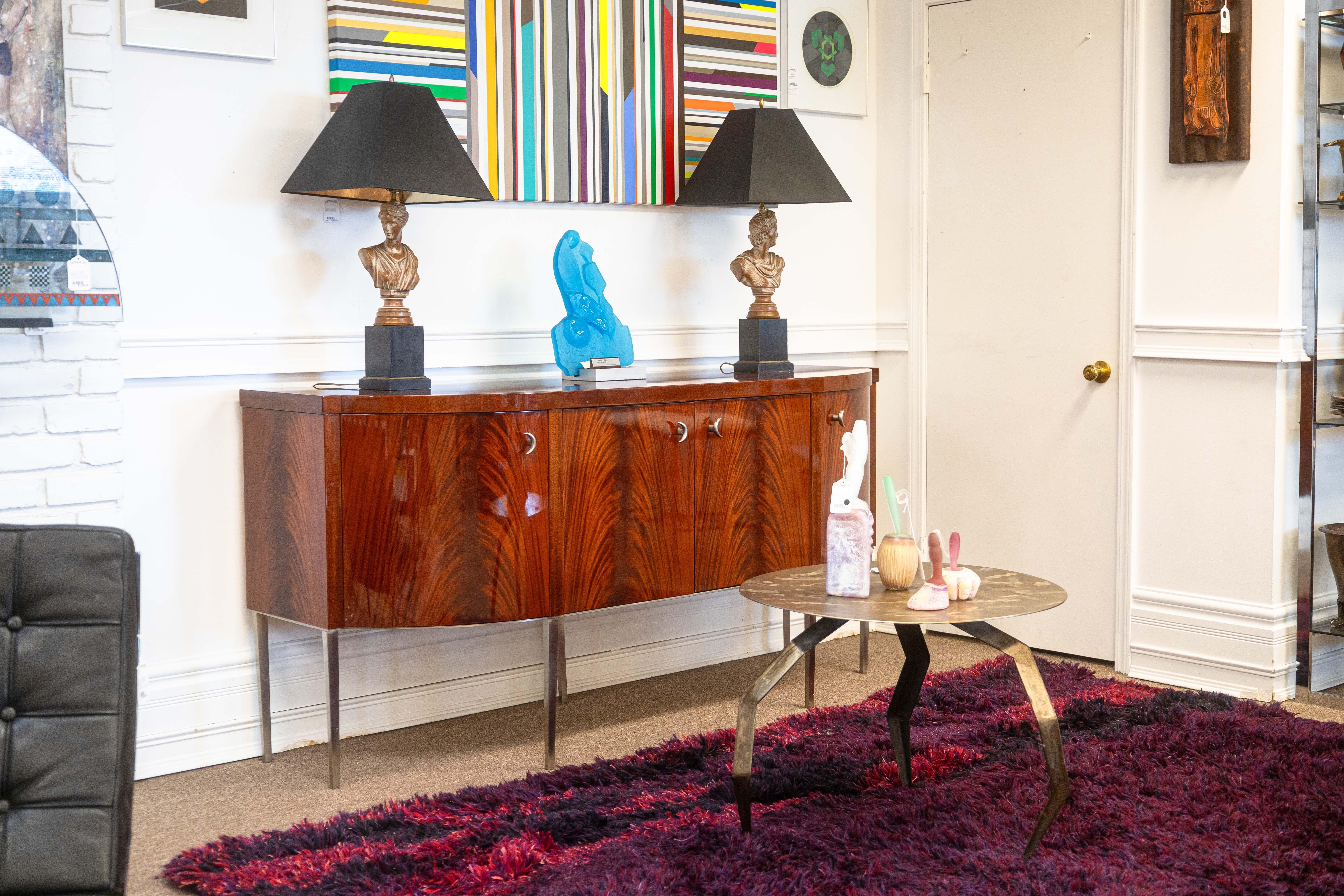 A vintage Greg Sheres Italian mahogany Verite collection buffet credenza. A stunning storage unit featuring a lovely design by Greg Sheres. This piece features a long rectangular shape with soft, rounded sides. The face features four doors with