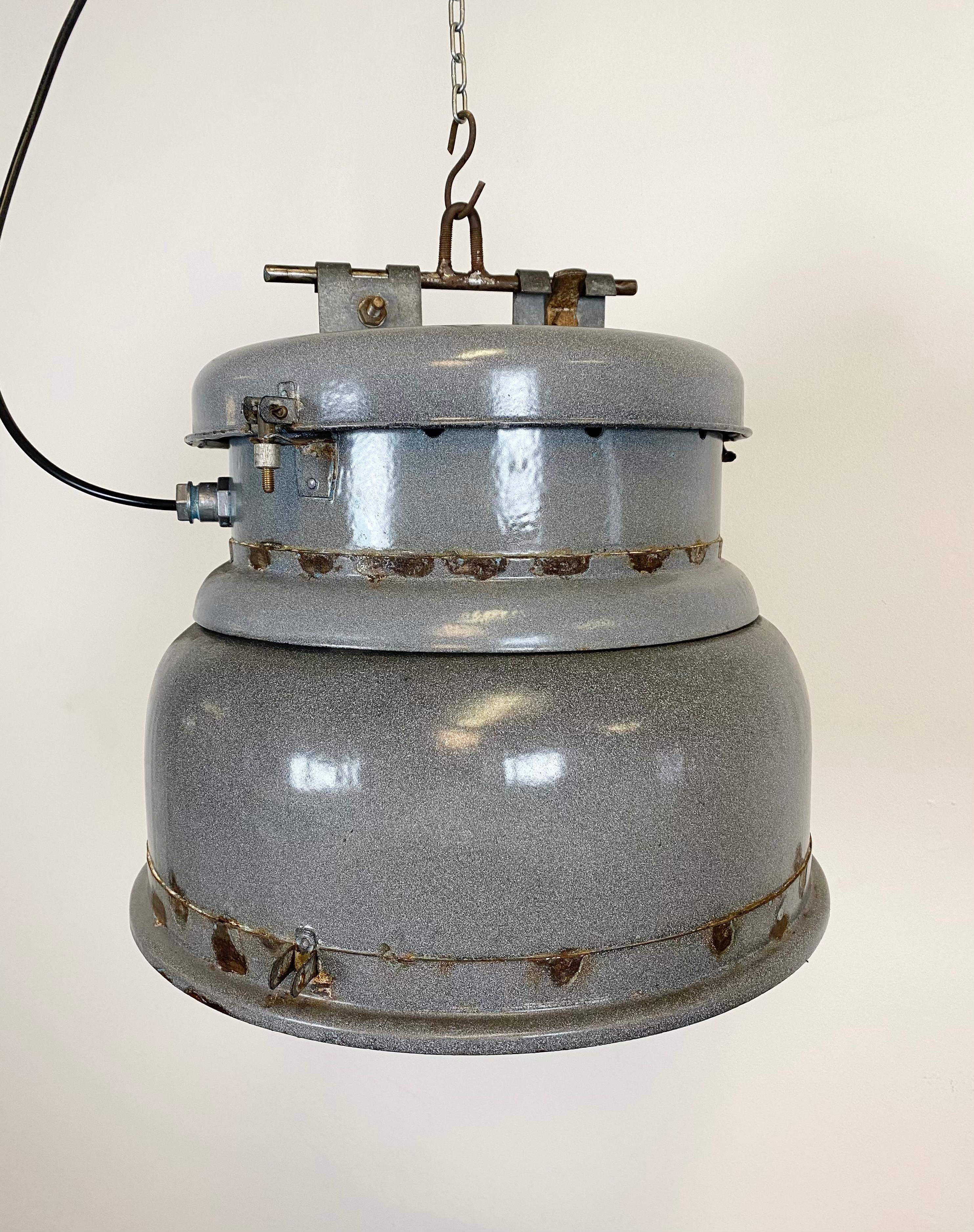 Industrial factory hanging light with grey enamel and white interior. Iron top.
New porcelain socket for E 27 lightbulbs and wire. The weight of the light is 9 kg.