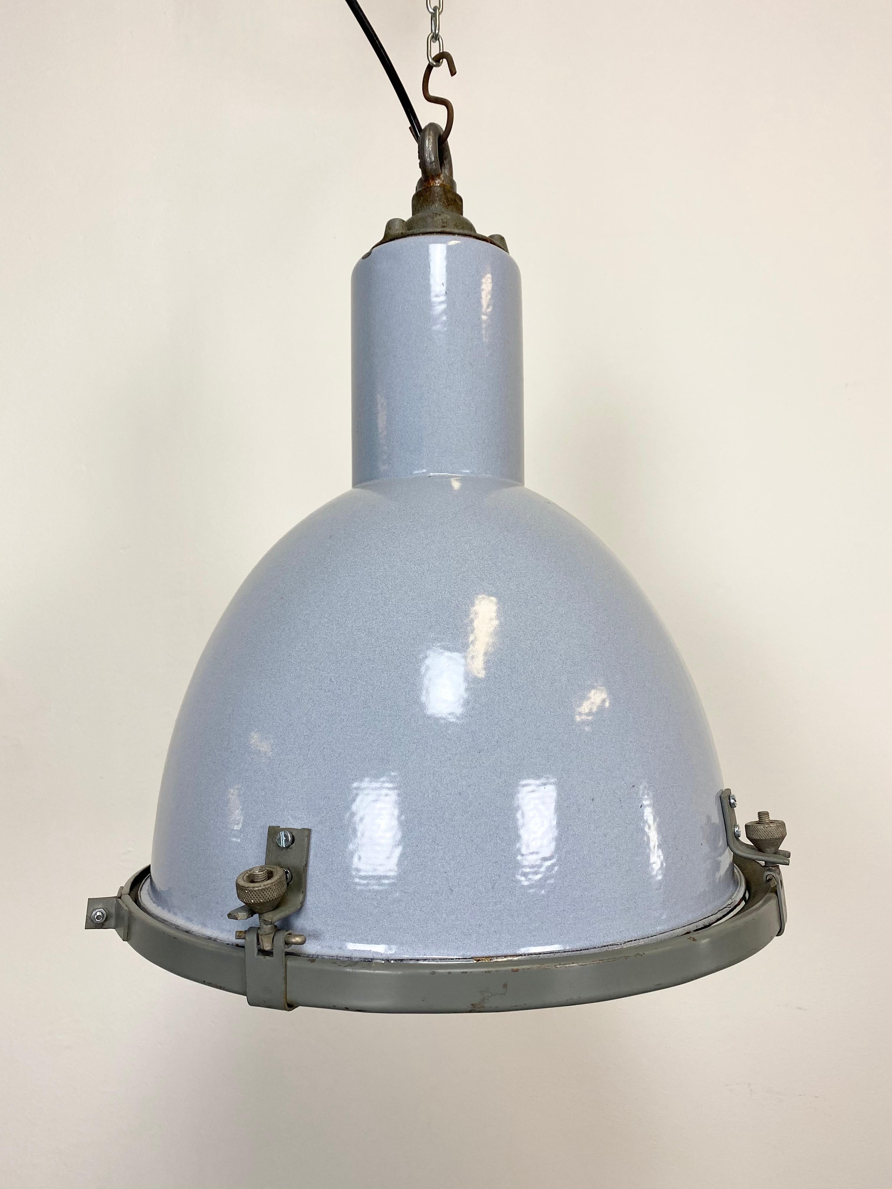 Vintage Industrial lamp made in former Czechoslovakia during the 1940s. It features a grey enamel shade with white interior, iron top and clear glass cover. New porcelain socket for E27 lightbulbs and new wire. The weight of the lamp is 4kg.