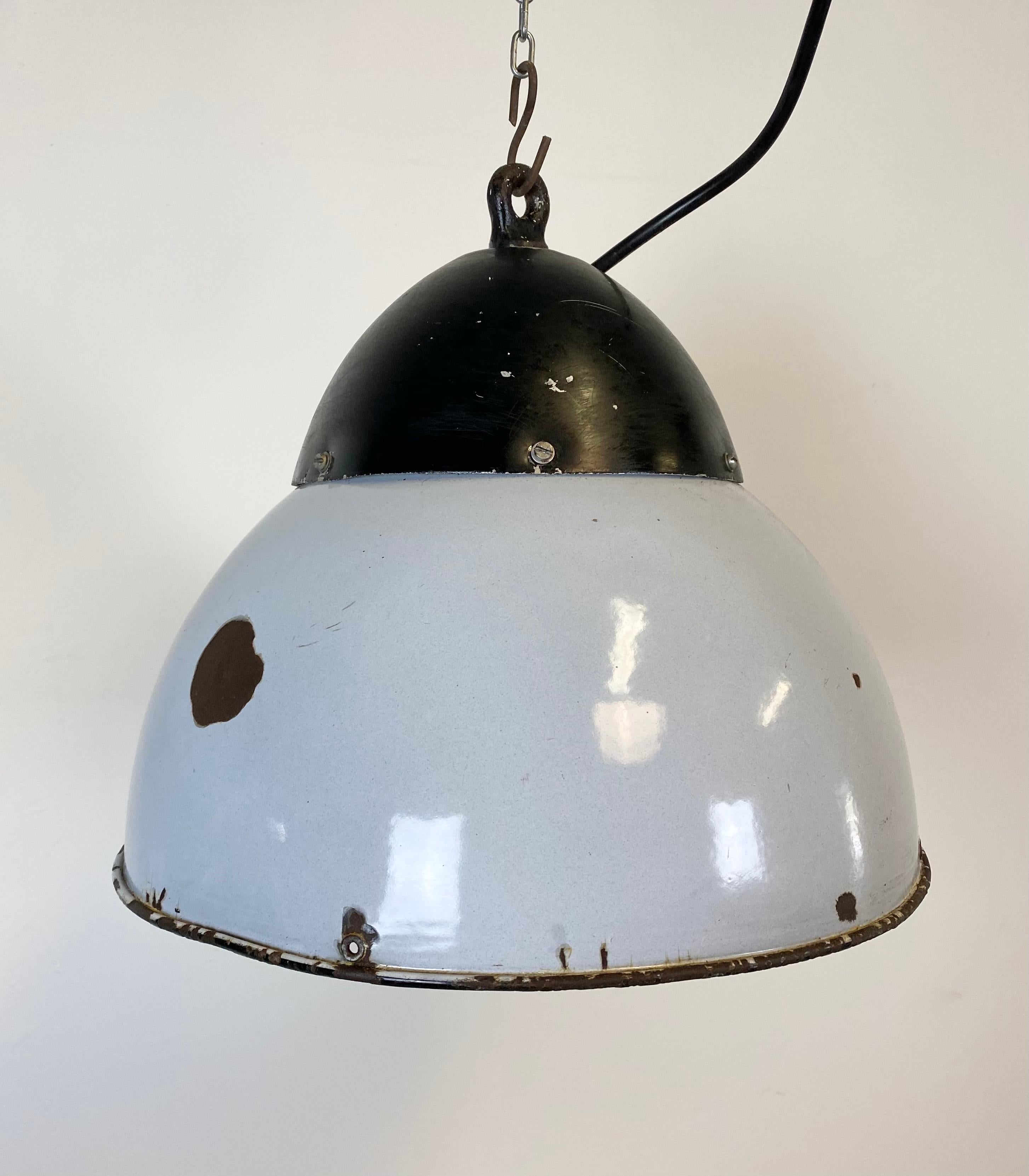 Very old industrial hanging lamp from former Czechoslovakia, 1930s.
Lamp has a black metal dome and a grey enamel lampshade. White interior. Interesting patina.
New socket for E 27 lightbulbs and wire.
Fully functional. The weight of the lamp is