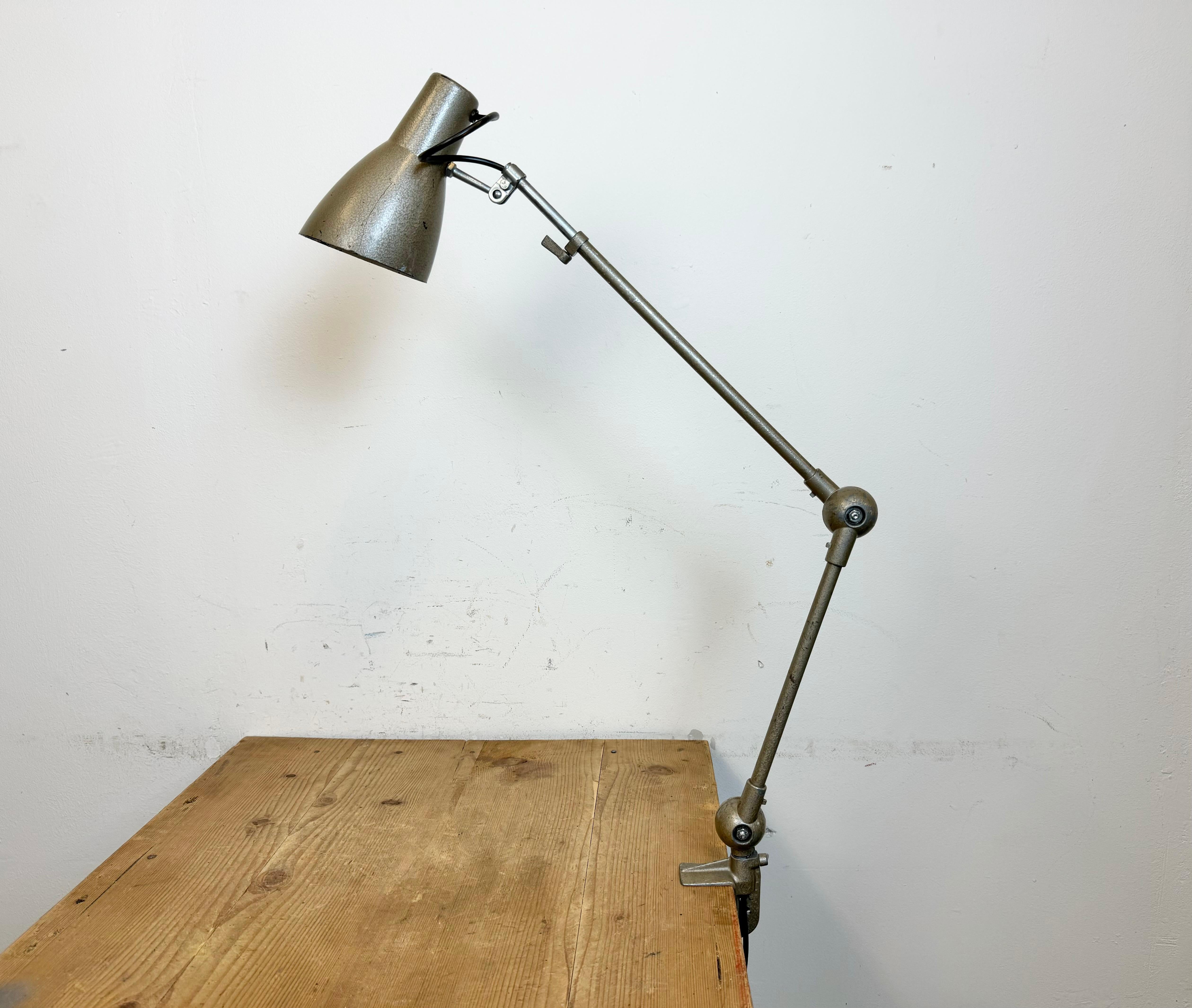Vintage workshop grey hammerpaint table lamp with adjustable height and angle made by AB Depose in France during the 1960. It features a bakelite shade, an iron arm and clamp base.The original socket requires  E 14 light bulbs. New wire.