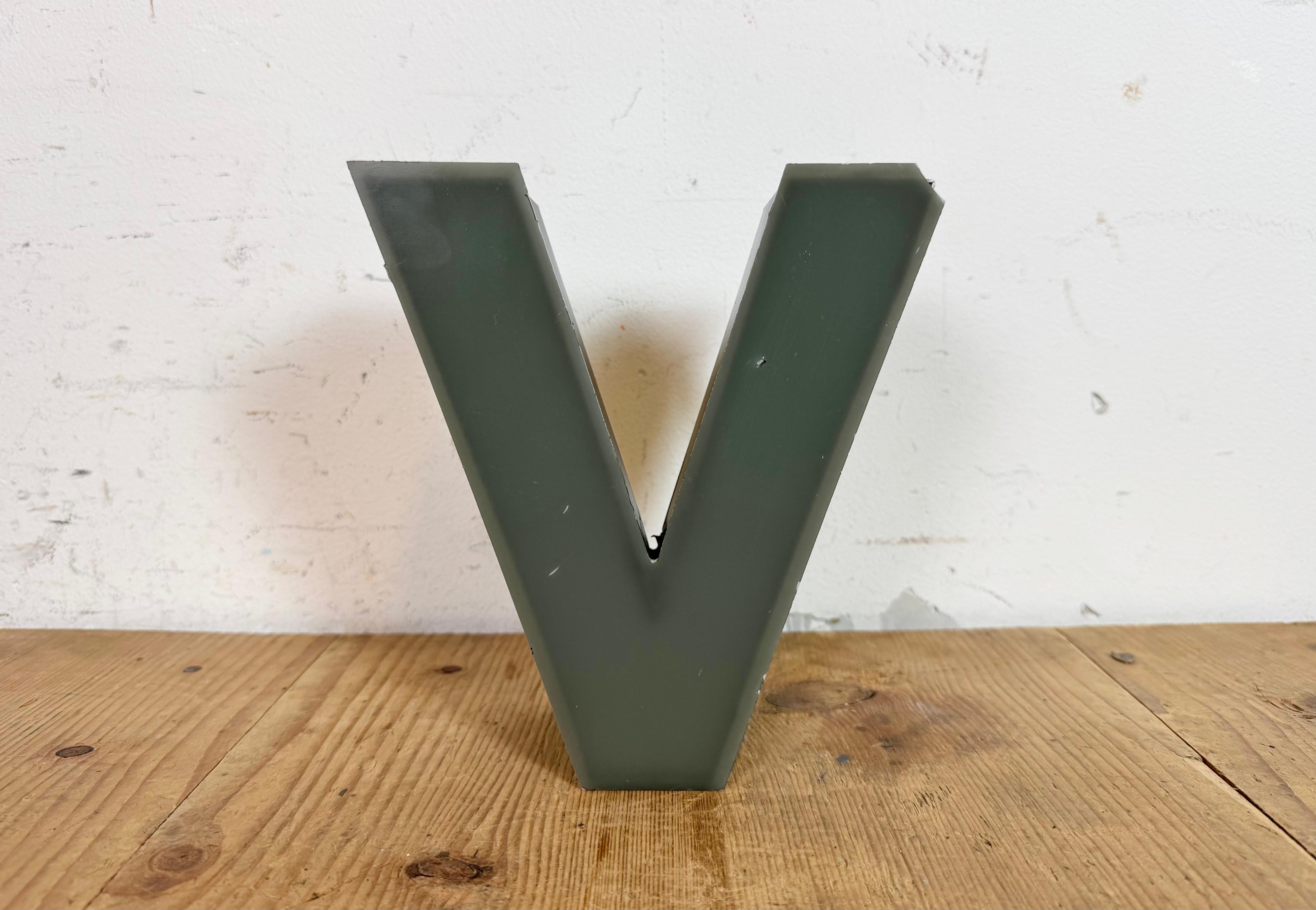 This vintage industrial illuminated letter “ V “ was made in Germany during the 1970s and comes from an old advertising banner. It features a black metal body and a grey plastic cover. It is equipped with a LED strip. The letter can be used as a