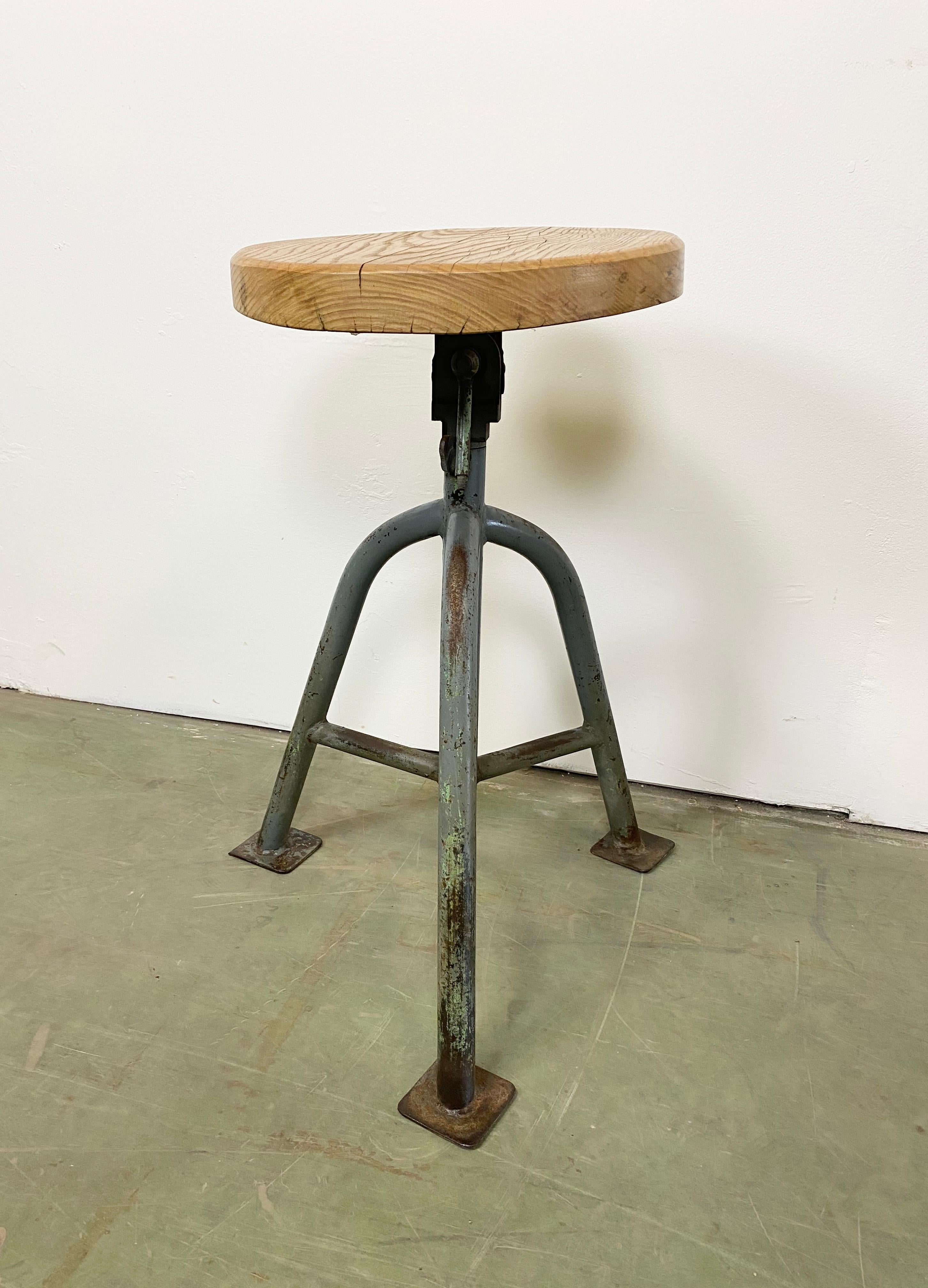 Industrial stool with a wooden seat and grey metal frame. The seat diameter is 37 cm. The weight of the stool is 11 kg.