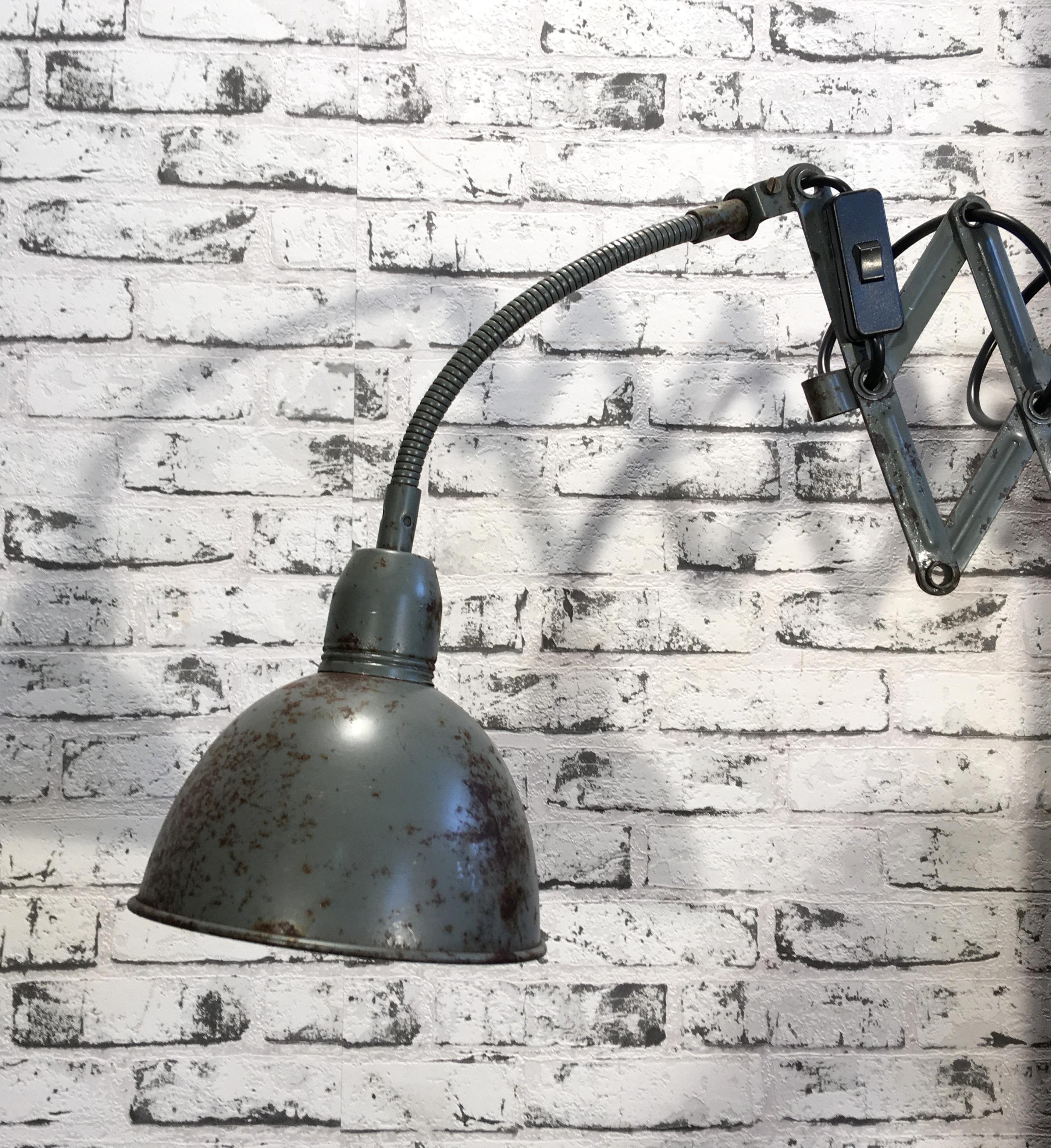 This vintage iron industrial scissor lamp was produced by Elektroinstala in former Czechoslovakia during the 1960s.Lamp has grey lampshade. Scissor arm is extendable and can be turned sideways. Socket for E 27 bulbs. Fully