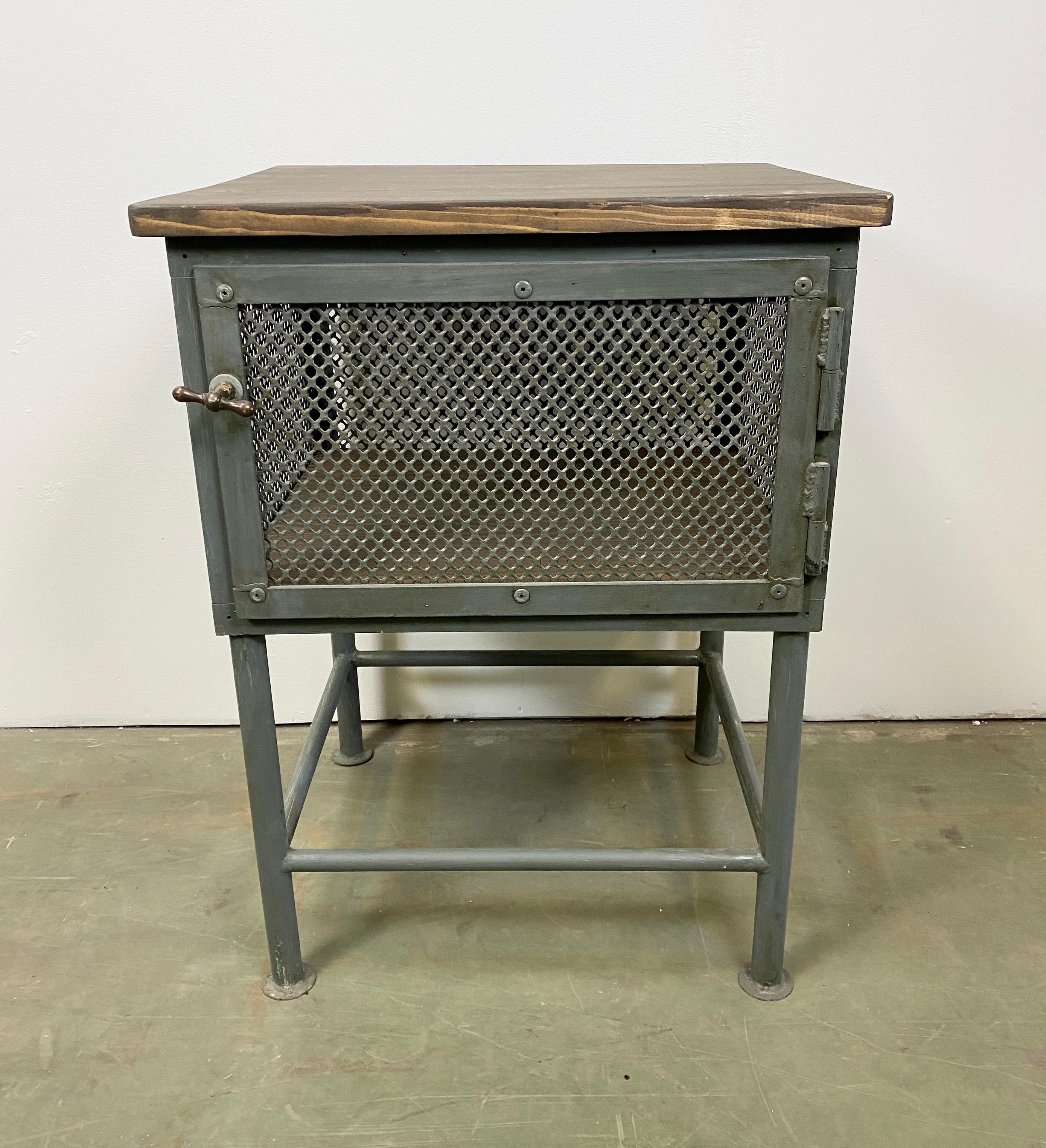 Industrial worktable with storage space from the 1960s. It features a grey iron construction and wooden plate. The weight of the table is 27 kg.