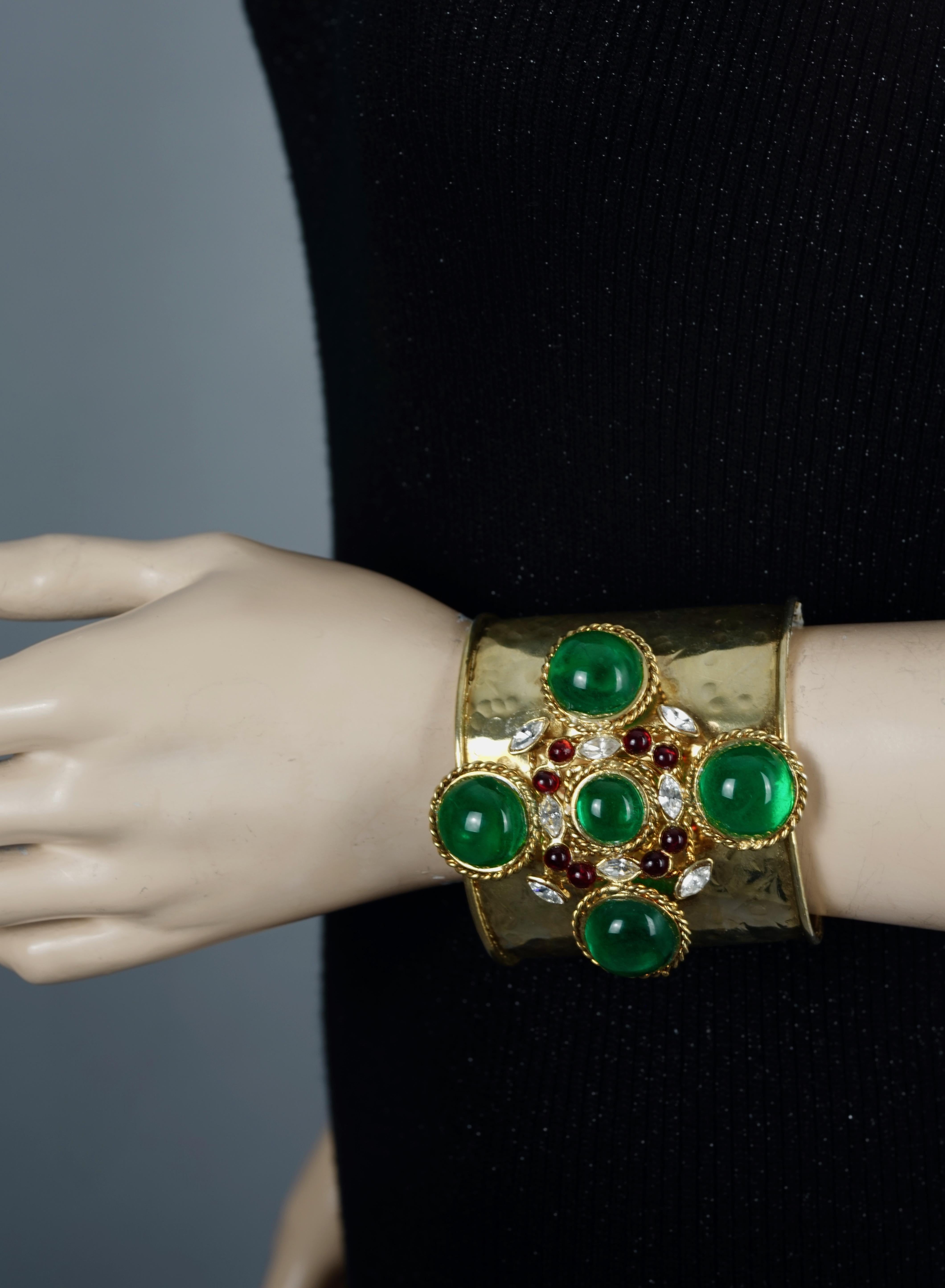 Vintage Gripoix Byzantine Haute Couture Cuff Bracelet

Measurements:
Height: 3 2/8 inches
Inner Diameter: 2 4/8 inches (across)
Opening: 1 3/8 inches

Features:
- Hammered cuff in Byzantine style.
- Cross center part is embellished with green, red