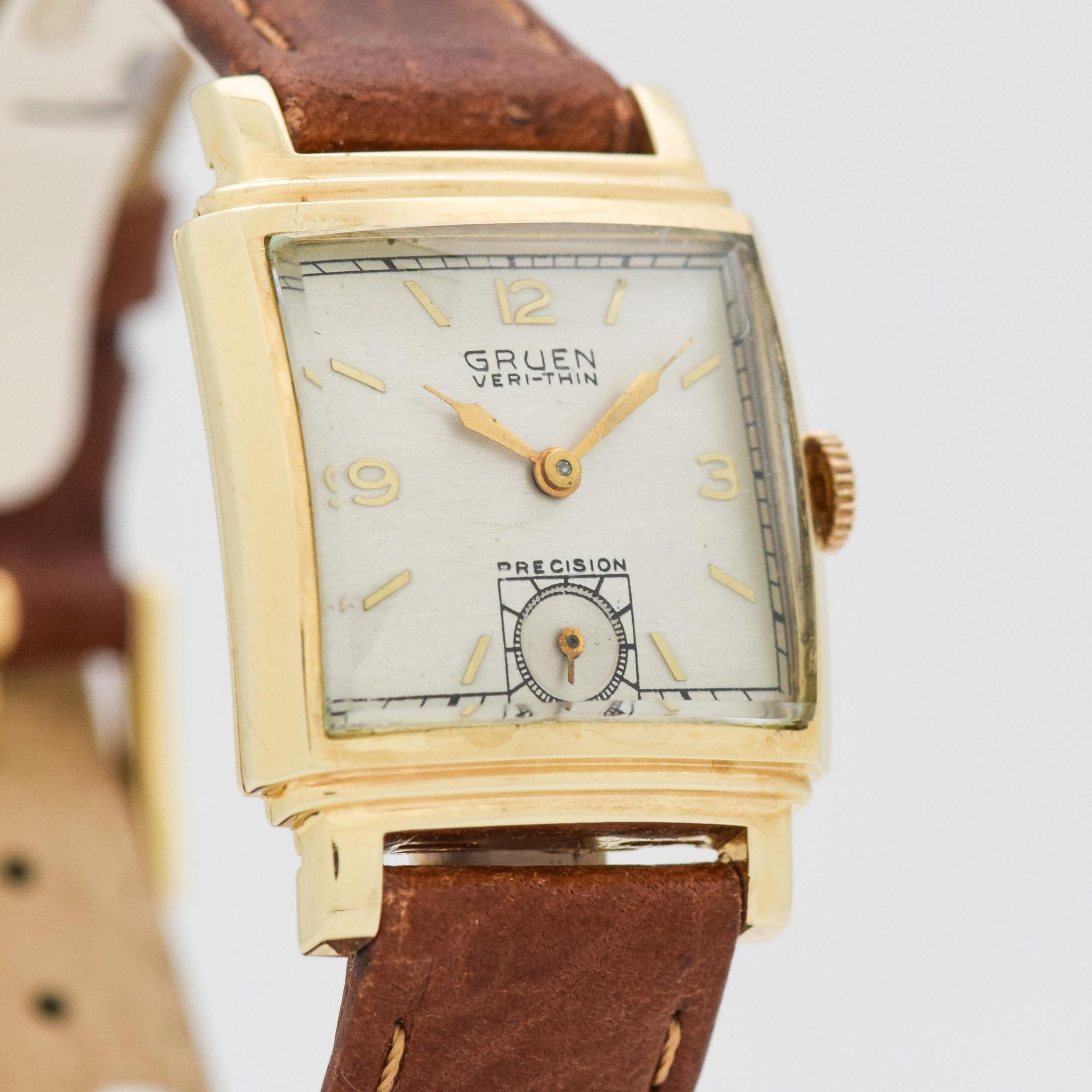 1947 Vintage Grue Veri-Thin Precision 14k Yellow Gold Stair Step Case watch with Silver Dial with Applied Gold Arabic 3, 9, and 12 with Stick/Bar/Baton Markers. 25mm x 35mm lug to lug (0.98 in. x 1.38 in.) - Powered by a 17-jewel, manual caliber