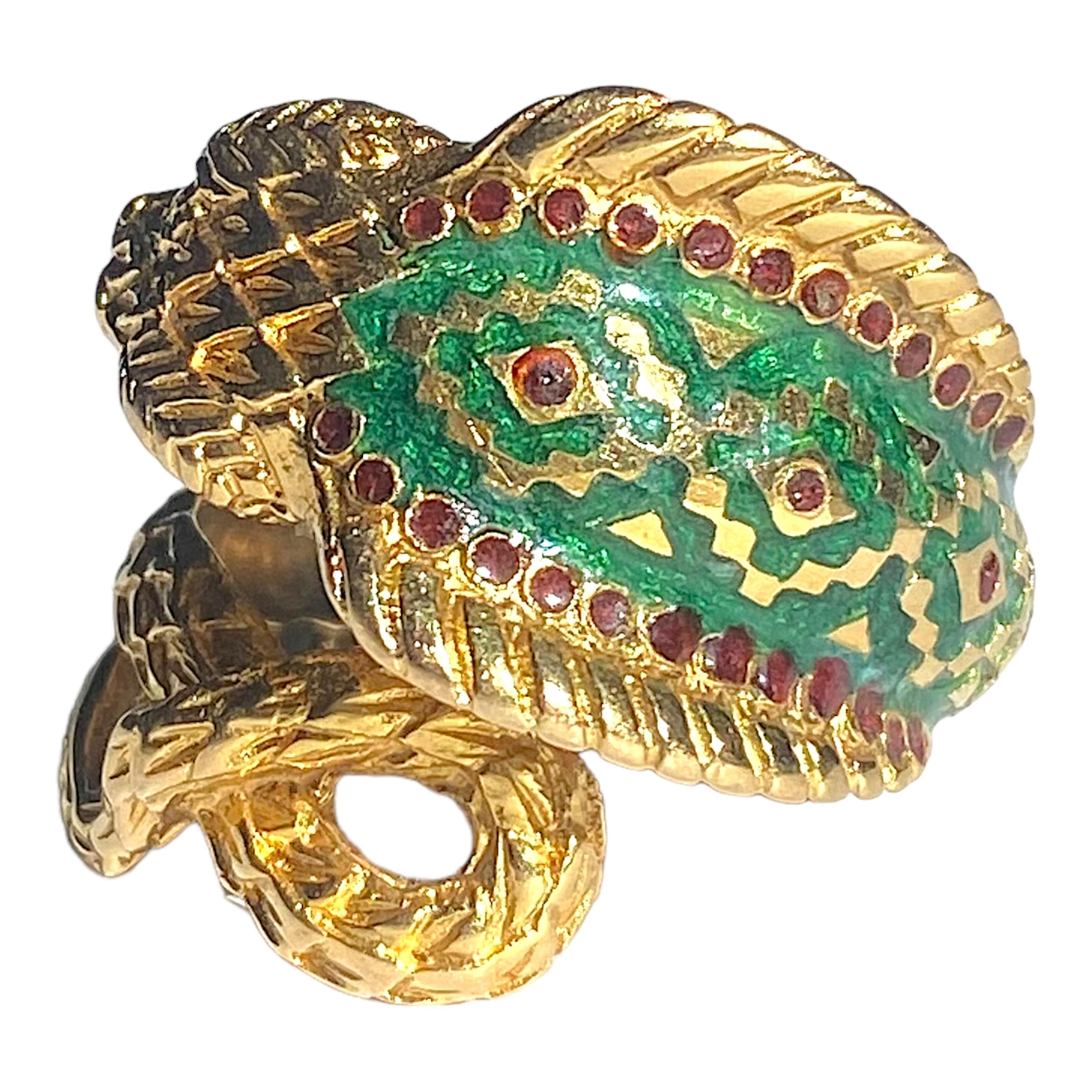 Crafted in 18K yellow gold, the ring features a coiling cobra design with green and red enamel.
Measurements:
Front: 21.5 mm W x 9 mm D
Back: 3 mm
Weight: 11.1 grams
Size: 6.5 (sizable)
Marked: GREECE 750 GSM (maker's mark)
Condition: Very good,