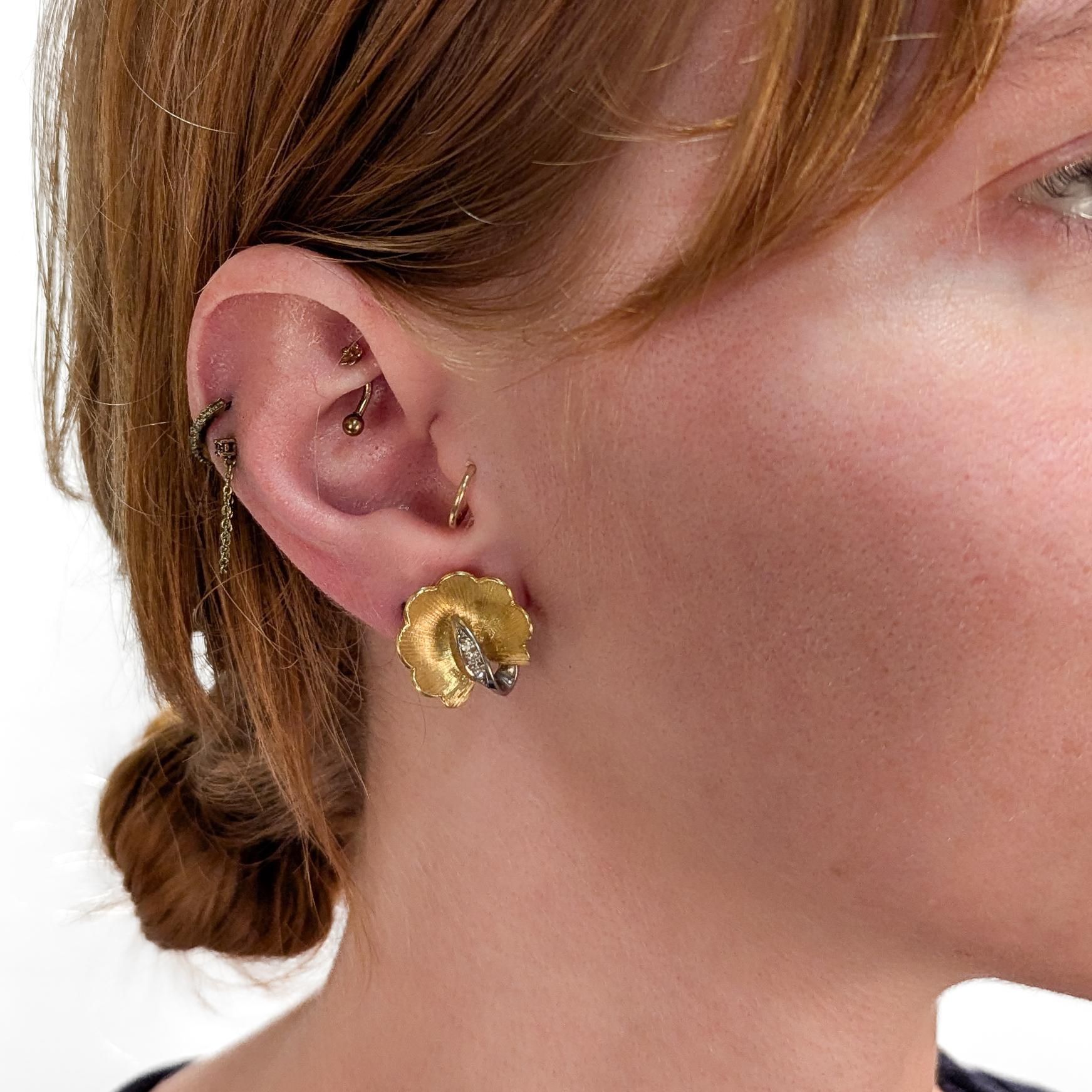 Ein feines, signiertes Paar Schweizer Gold- und Diamant-Ohrringe zum Anstecken.

Von Gubelin.

Aus 18 Karat Gelbgold.

Jeweils in Form einer Blume mit einem kleinen, mit 4 Diamanten besetzten Weißgoldblatt.

Die Rückseite ist mit Clipverschlüssen
