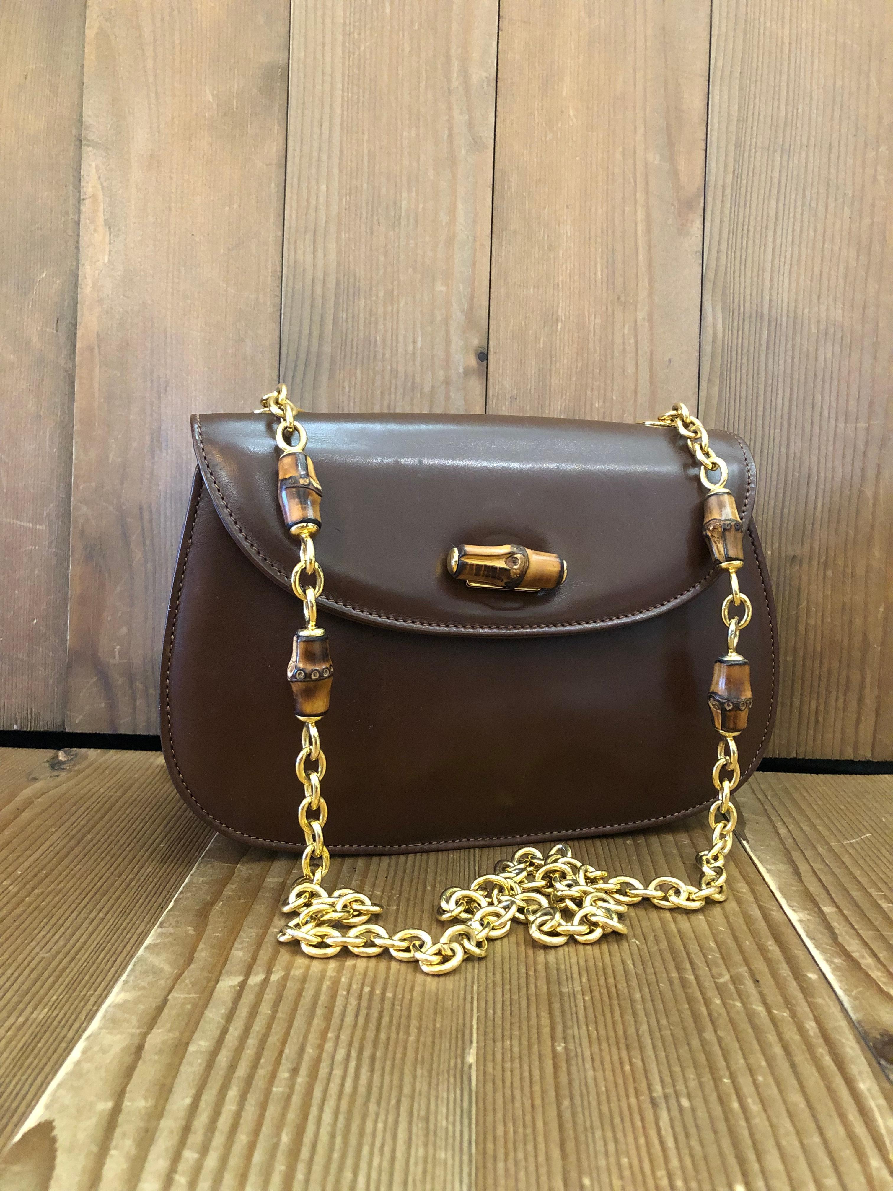 This vintage GUCCI bamboo chain shoulder bag is crafted of smooth calfskin leather in brown featuring a sturdy gold toned chain with bamboo internodes. Front flap bamboo turnlock closure opens to a new beige interior featuring a zippered pocket.