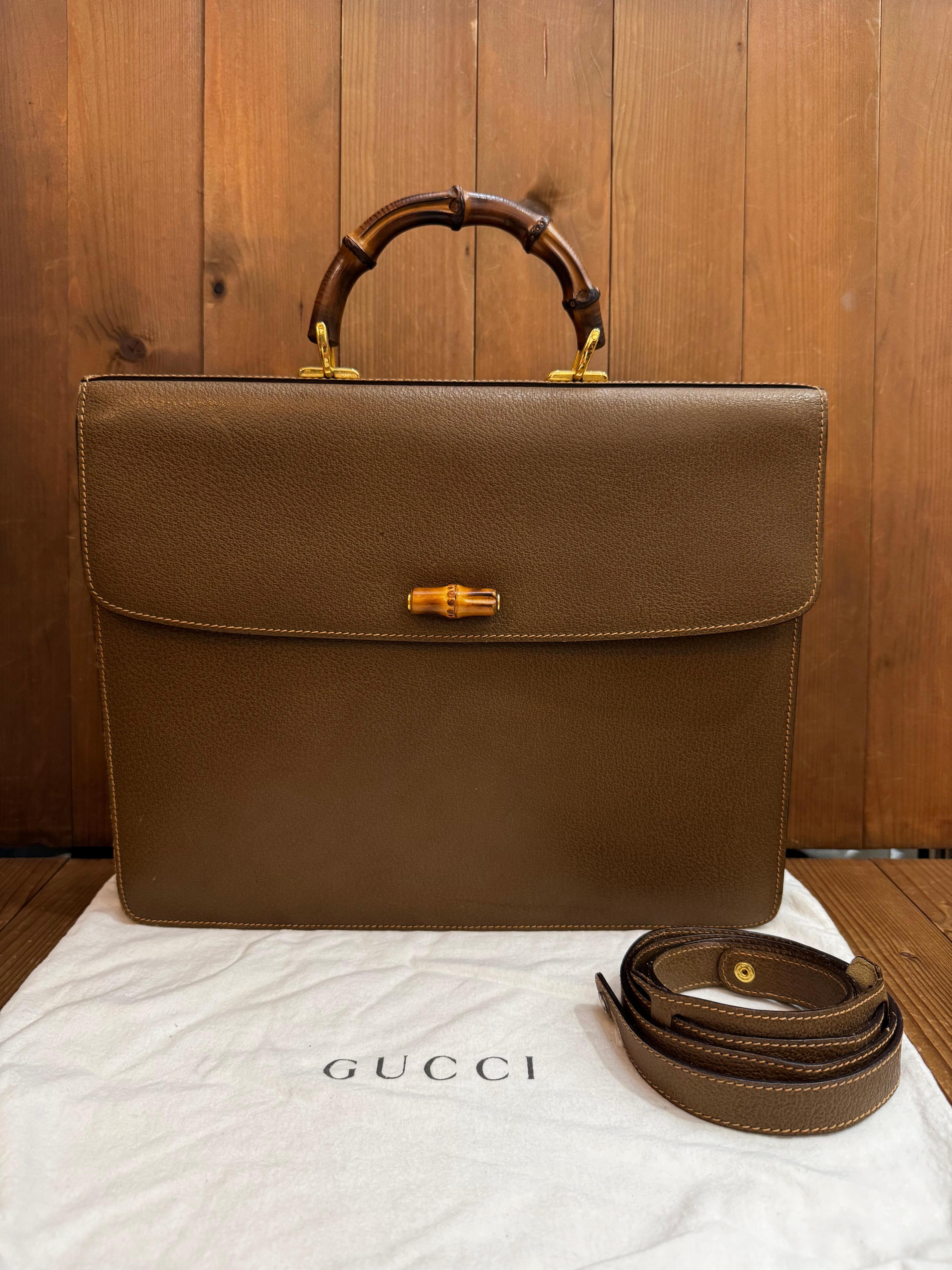 This vintage GUCCI bamboo briefcase/attache is crafted of pigskin leather in dark greenish brown featuring gold toned hardware, a sturdy bamboo handle, and s detachable shoulder strap of the same leather. Front pressed-hold bamboo closure opens to a