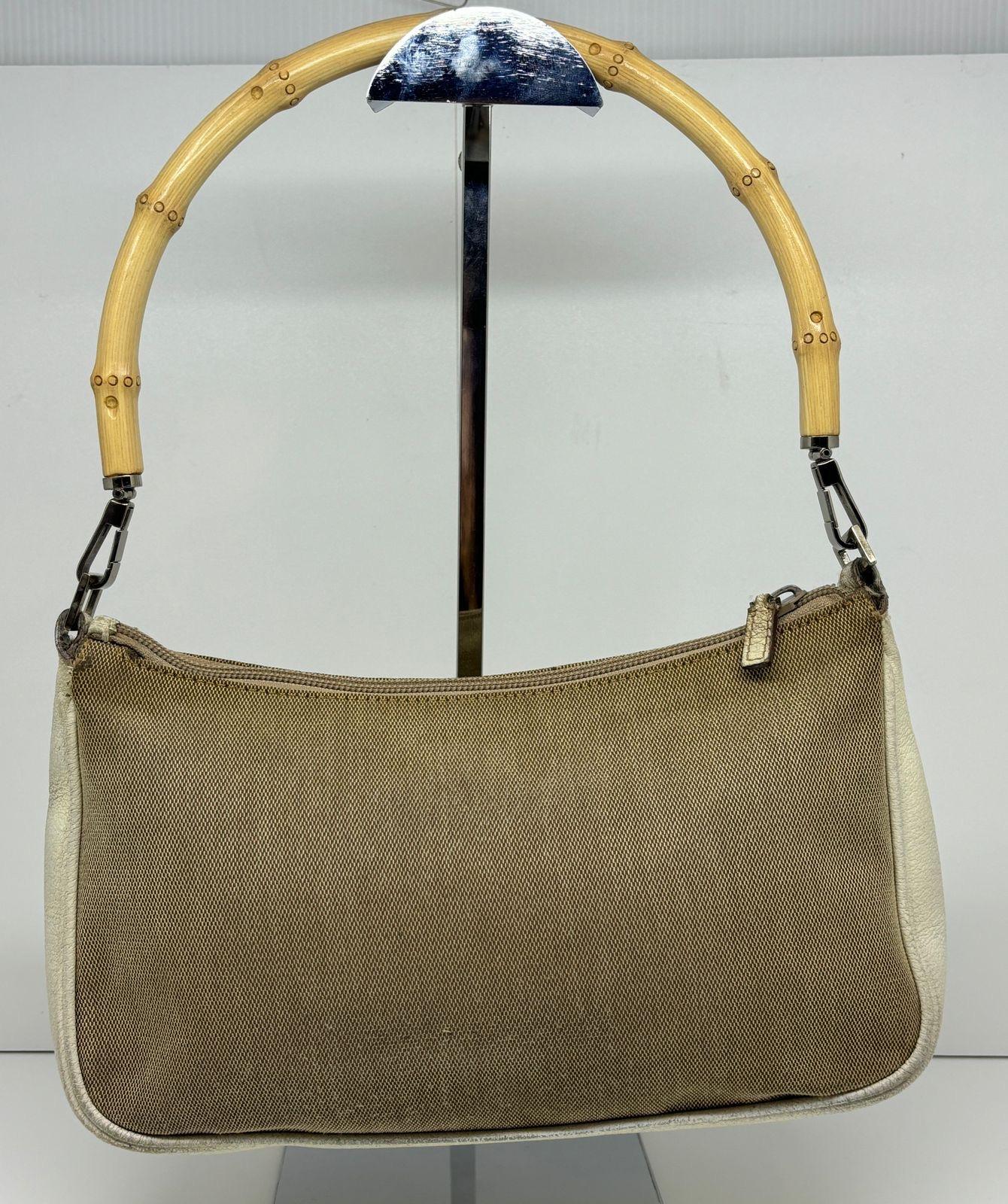 Gucci canvas bamboo handle pochette bag. Can be worn as shoulder bag. Overall in good vintage condition with minor rubbing marks on the canvas and leather area. Comes with dust bag only.