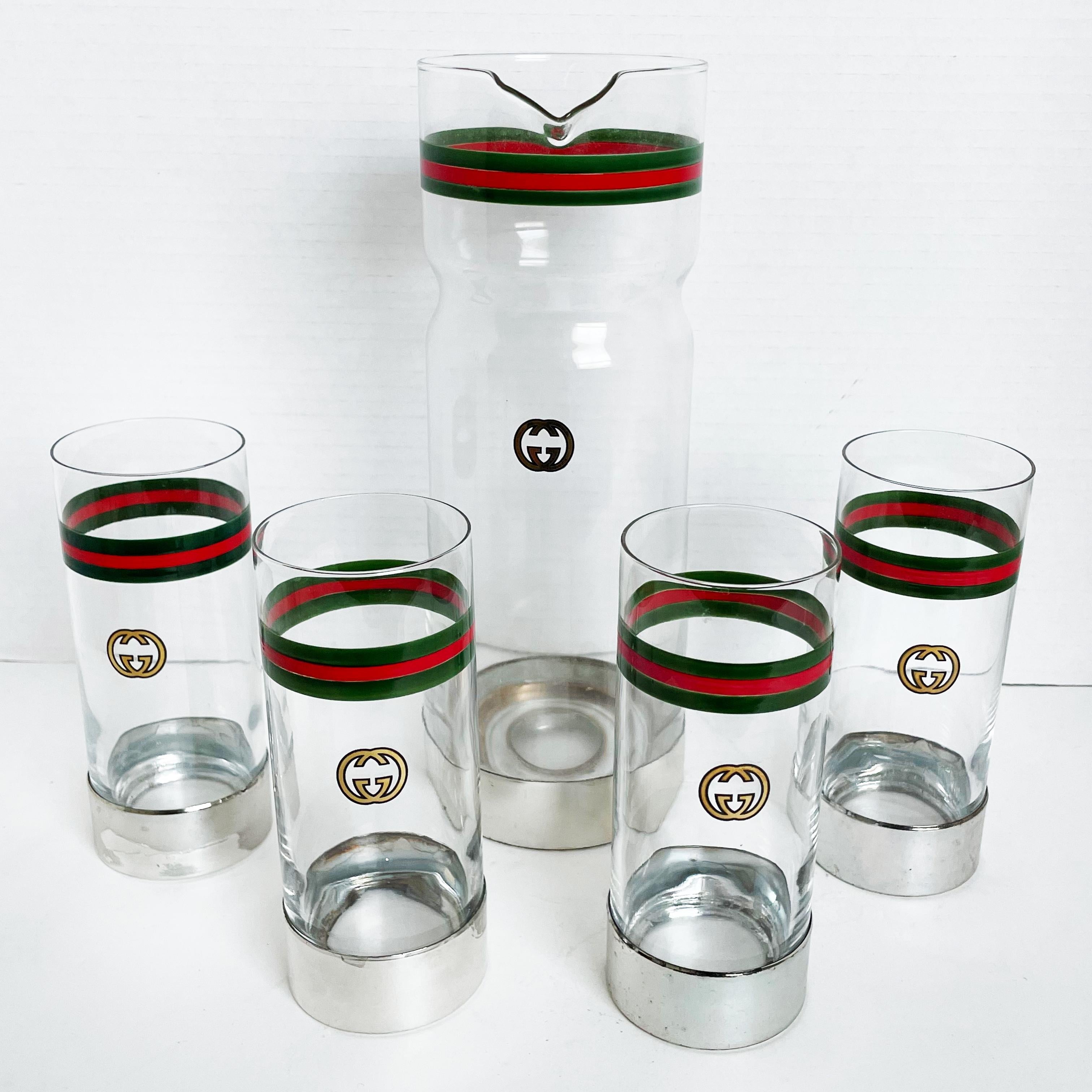 Entertain in style! Authentic, preowned, vintage Gucci 5pc barware set: GG Logo Webbing Pitcher or Carafe with 4 high ball glasses, likely made in the 80s.  Painted glass on silver metal base. Preowned/vintage with signs of prior use/wear: some